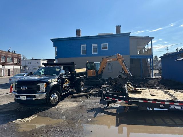 A tow truck is parked in front of a blue building.