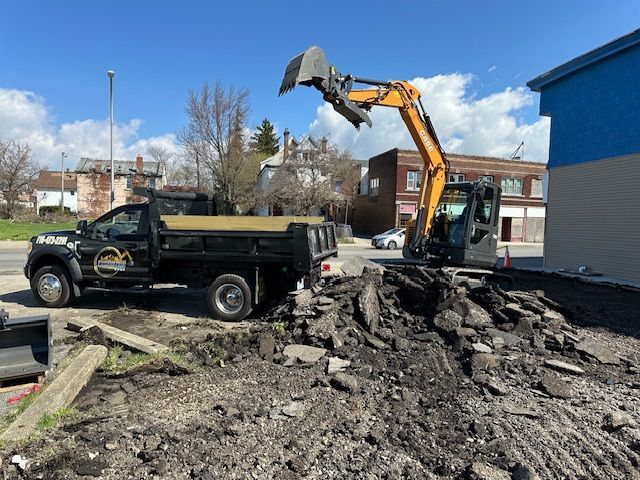 A truck is parked next to a large pile of dirt.