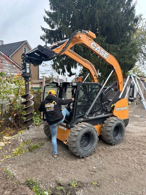 A man is standing next to a case skid steer loader.
