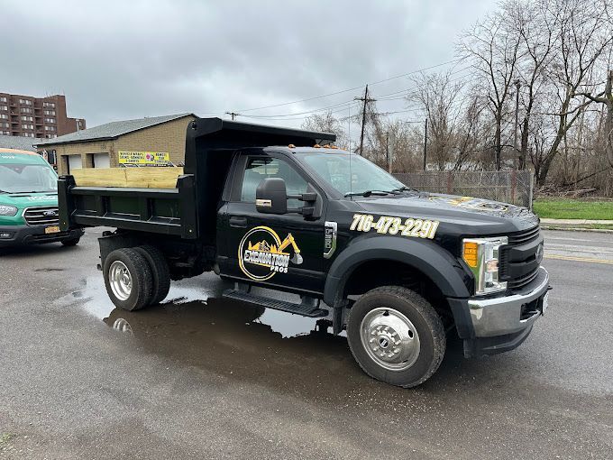 A black dump truck is parked on the side of the road.