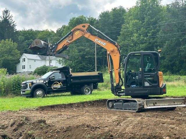 A case excavator is loading dirt into a dump truck.