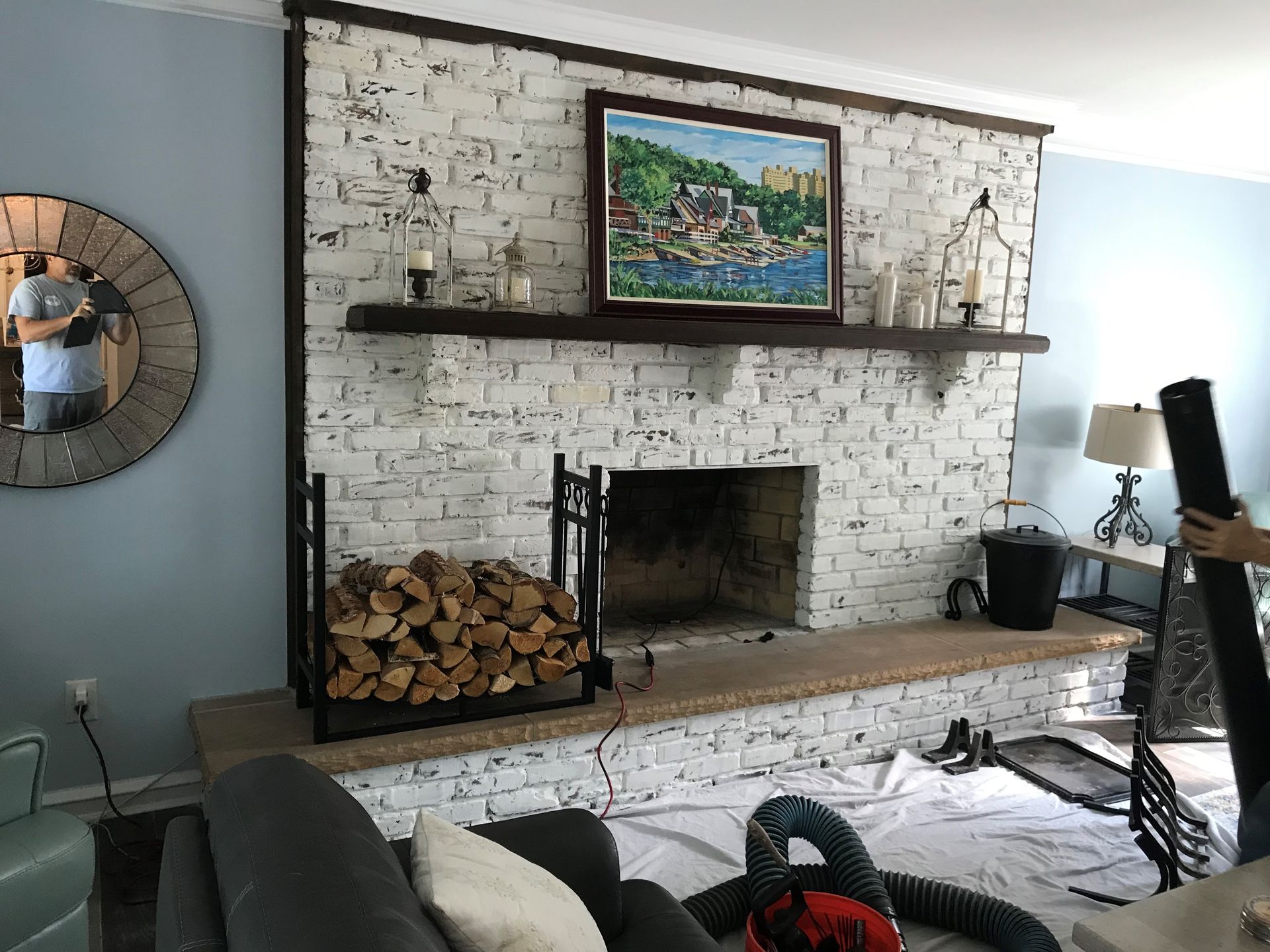 A living room with a fireplace and a painting on the wall.