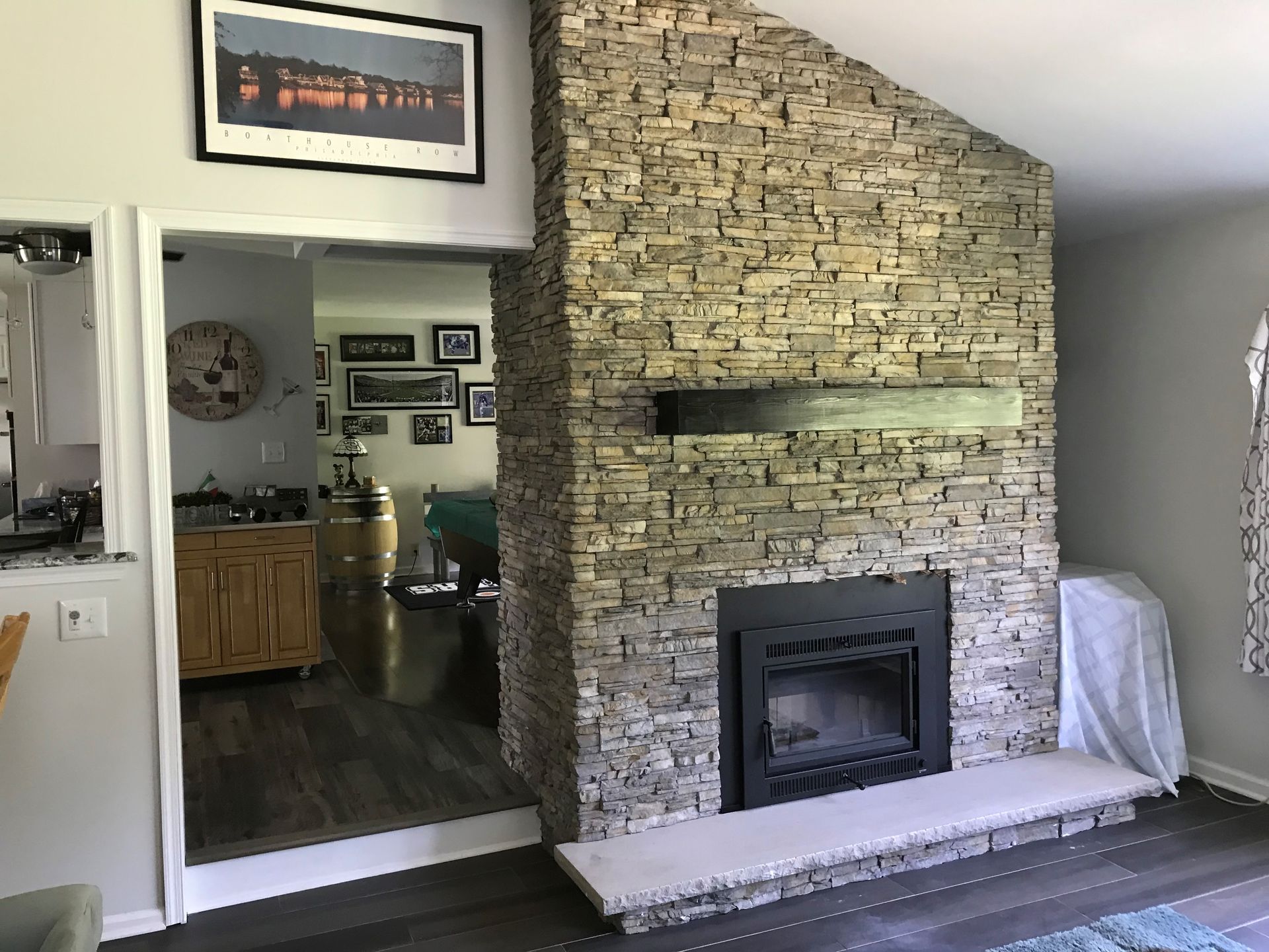 A living room with a fireplace and a picture on the wall above it.