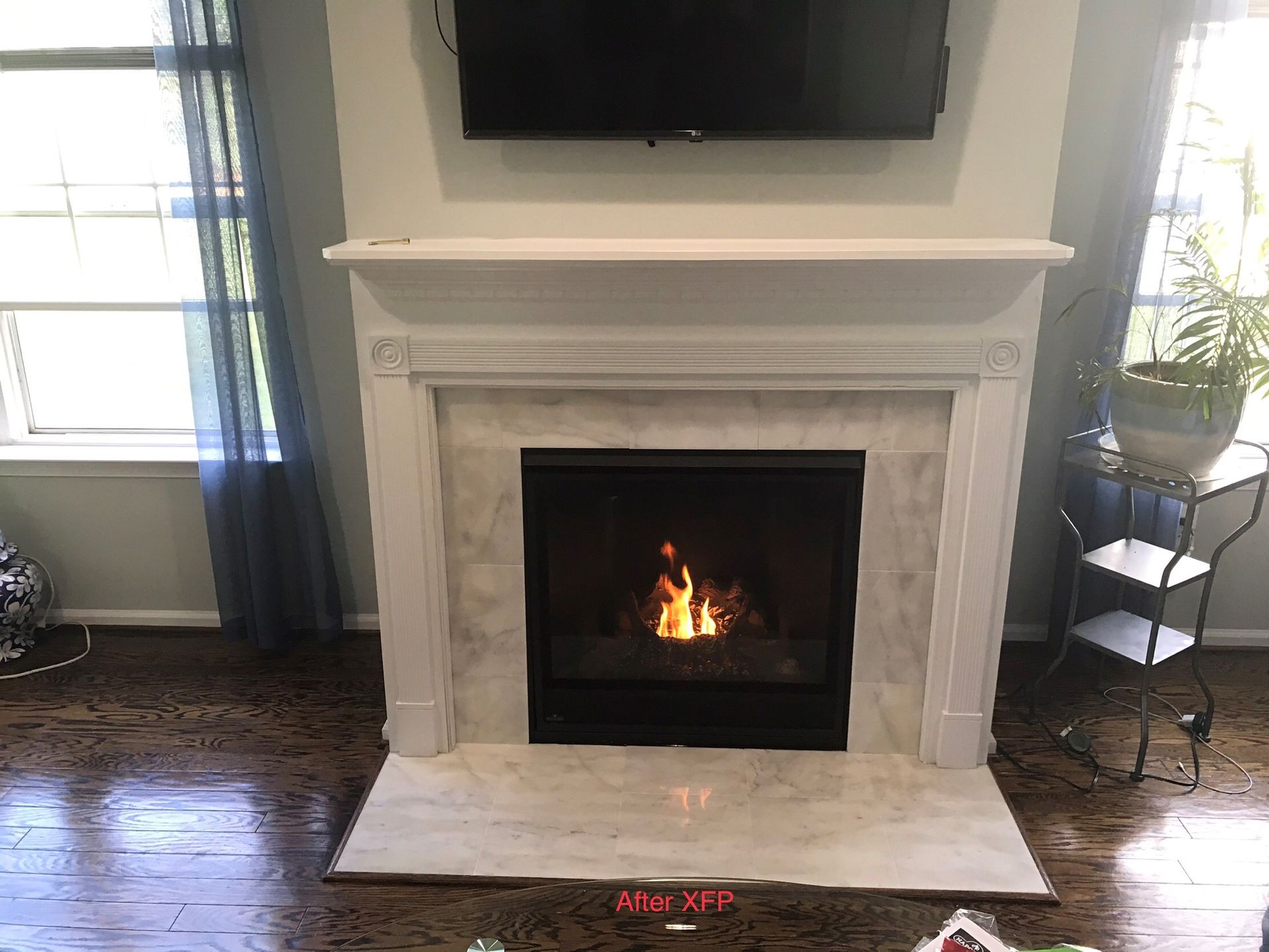A living room with a fireplace and a flat-screen TV.