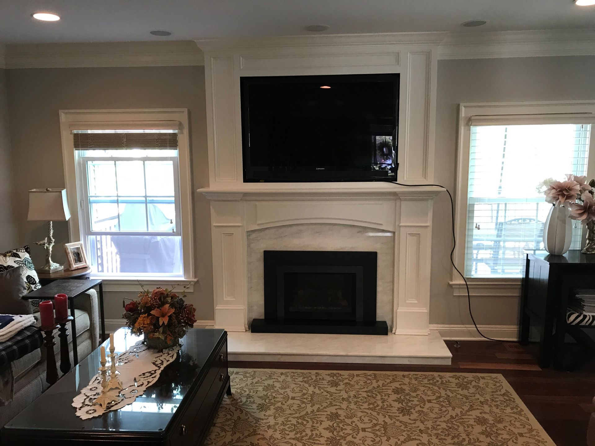 A living room with a fireplace and a flat-screen TV.