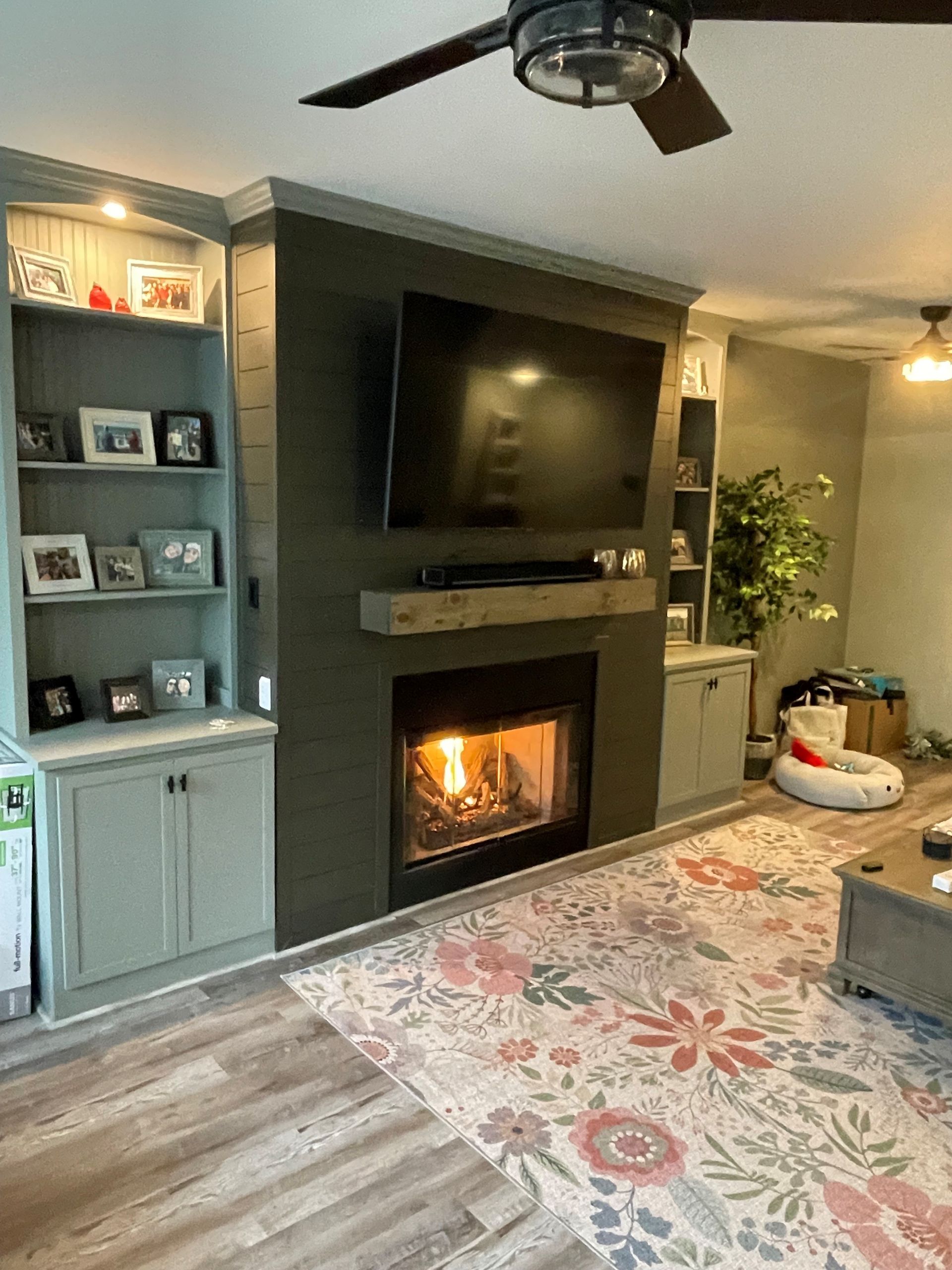A living room with a fireplace and a flat-screen TV.