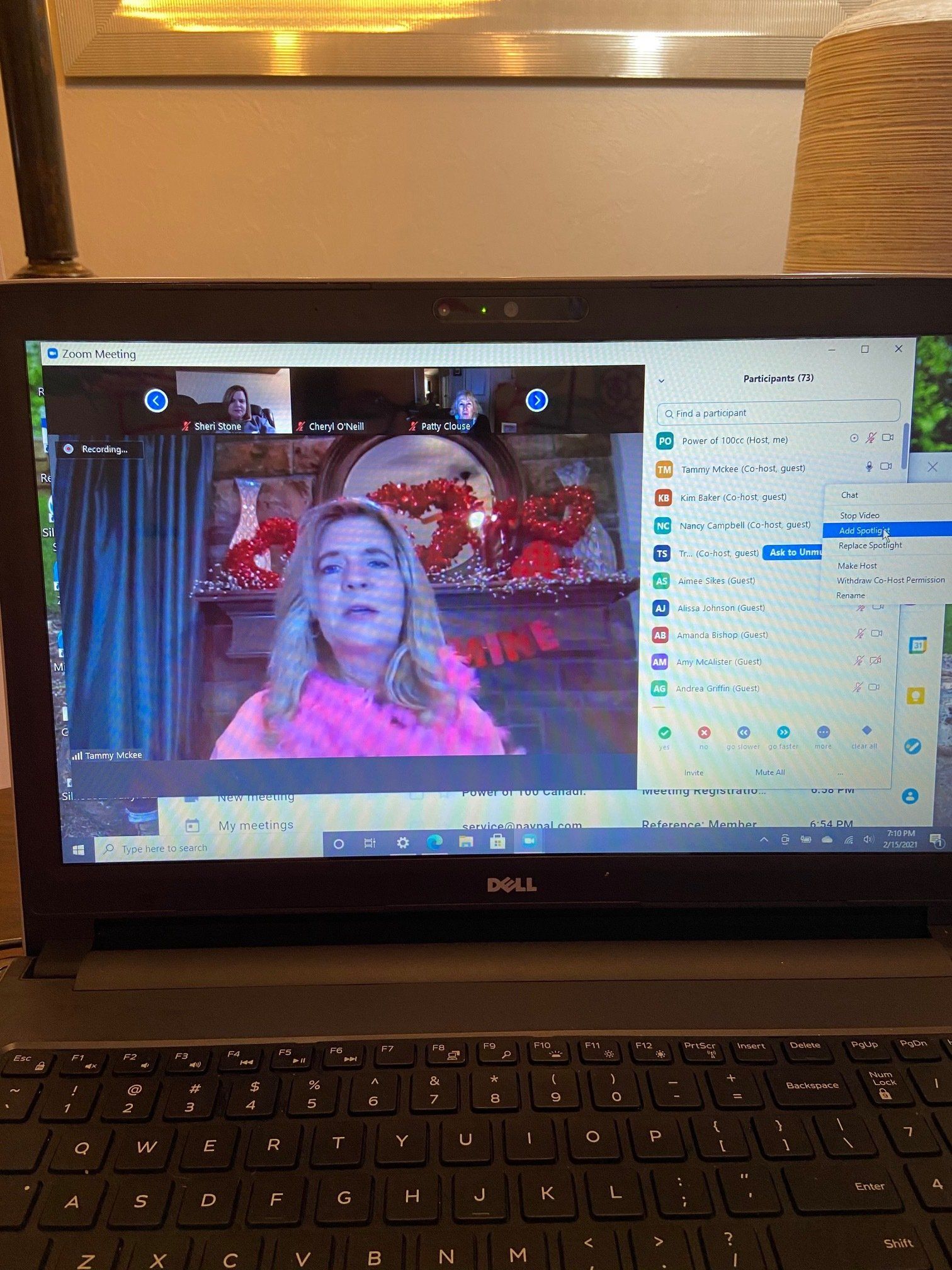 A dell laptop is open to a video call with a woman on the screen.
