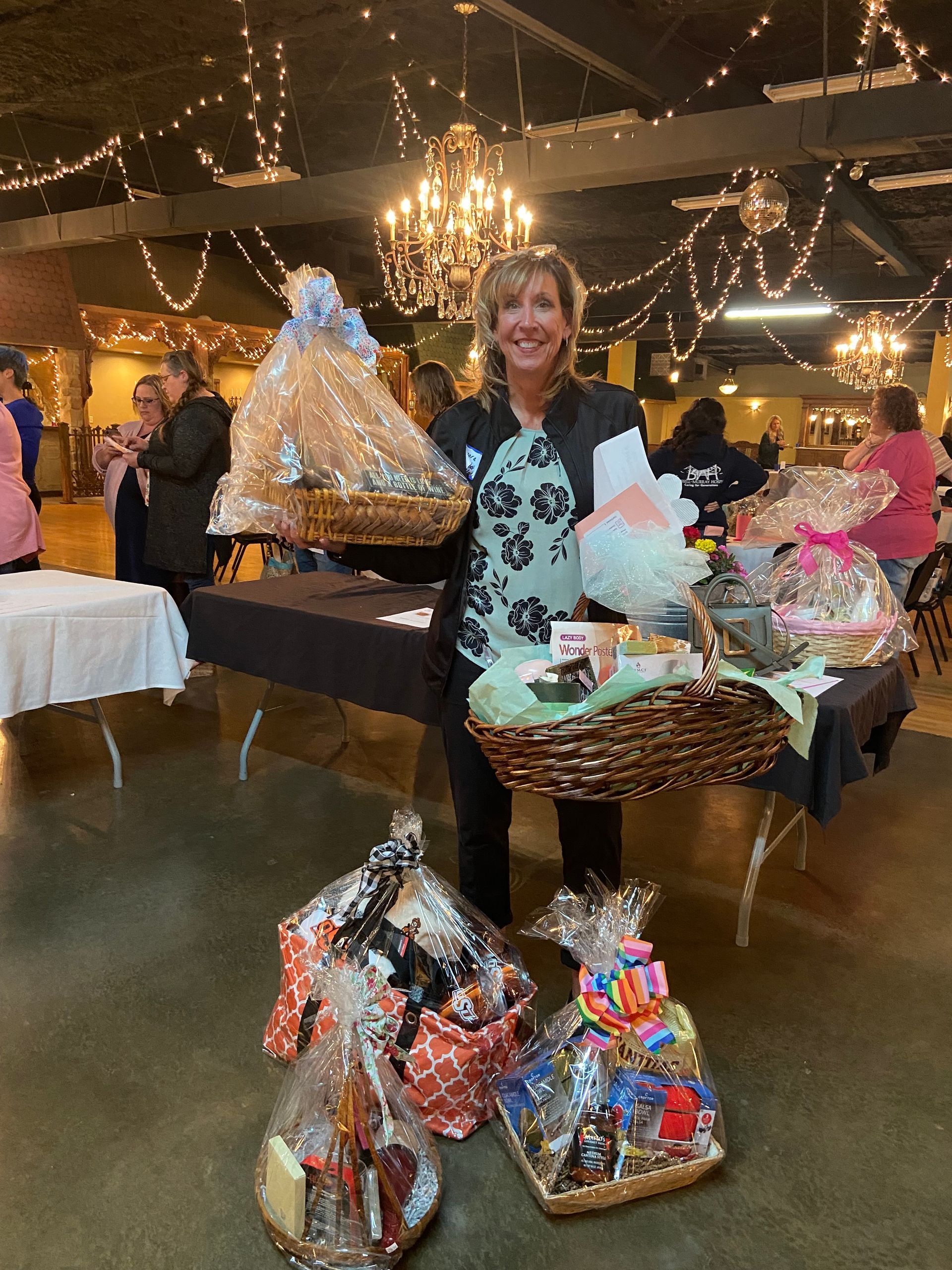 A woman is standing in front of a table full of baskets.
