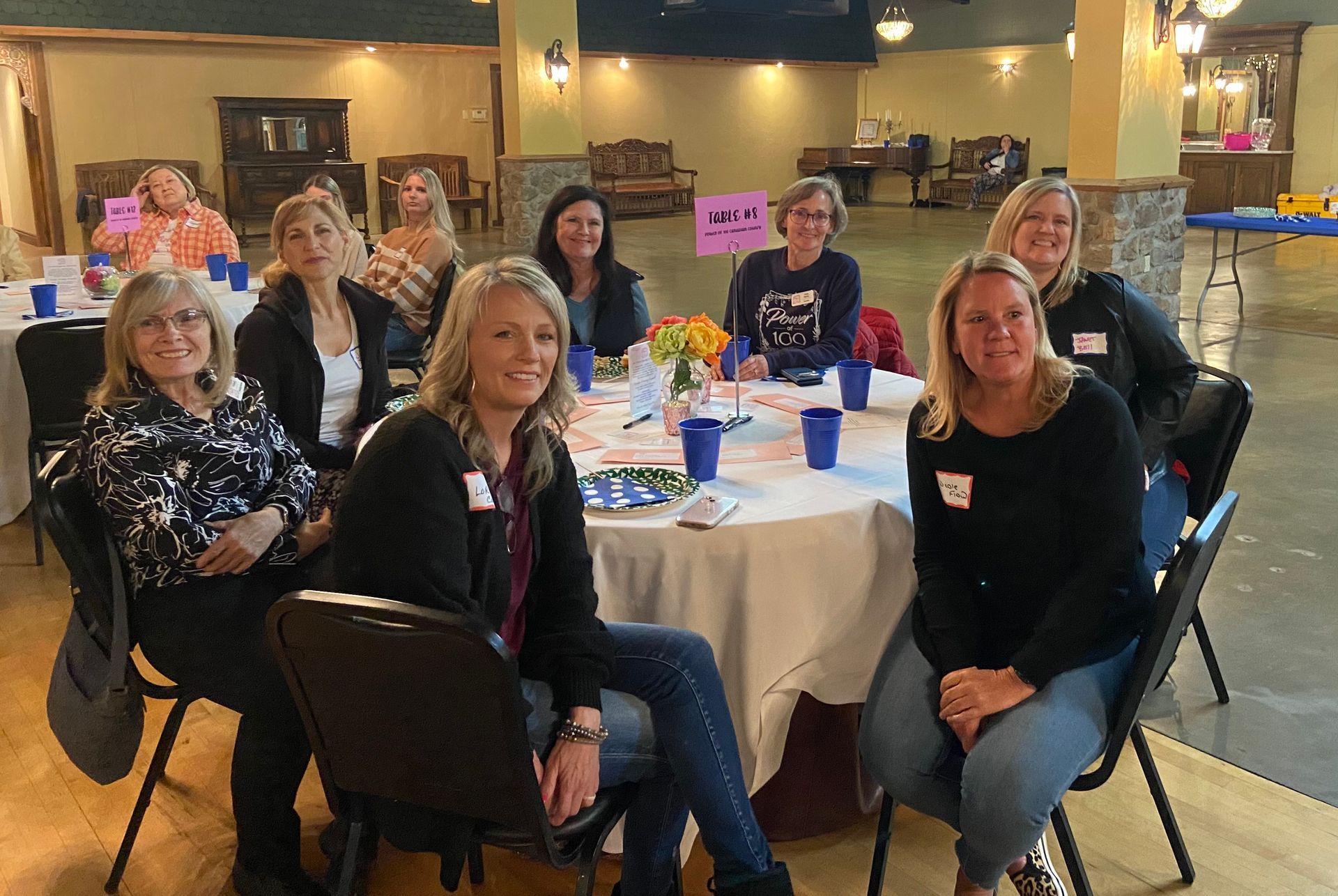 A group of women are sitting at tables in a room.
