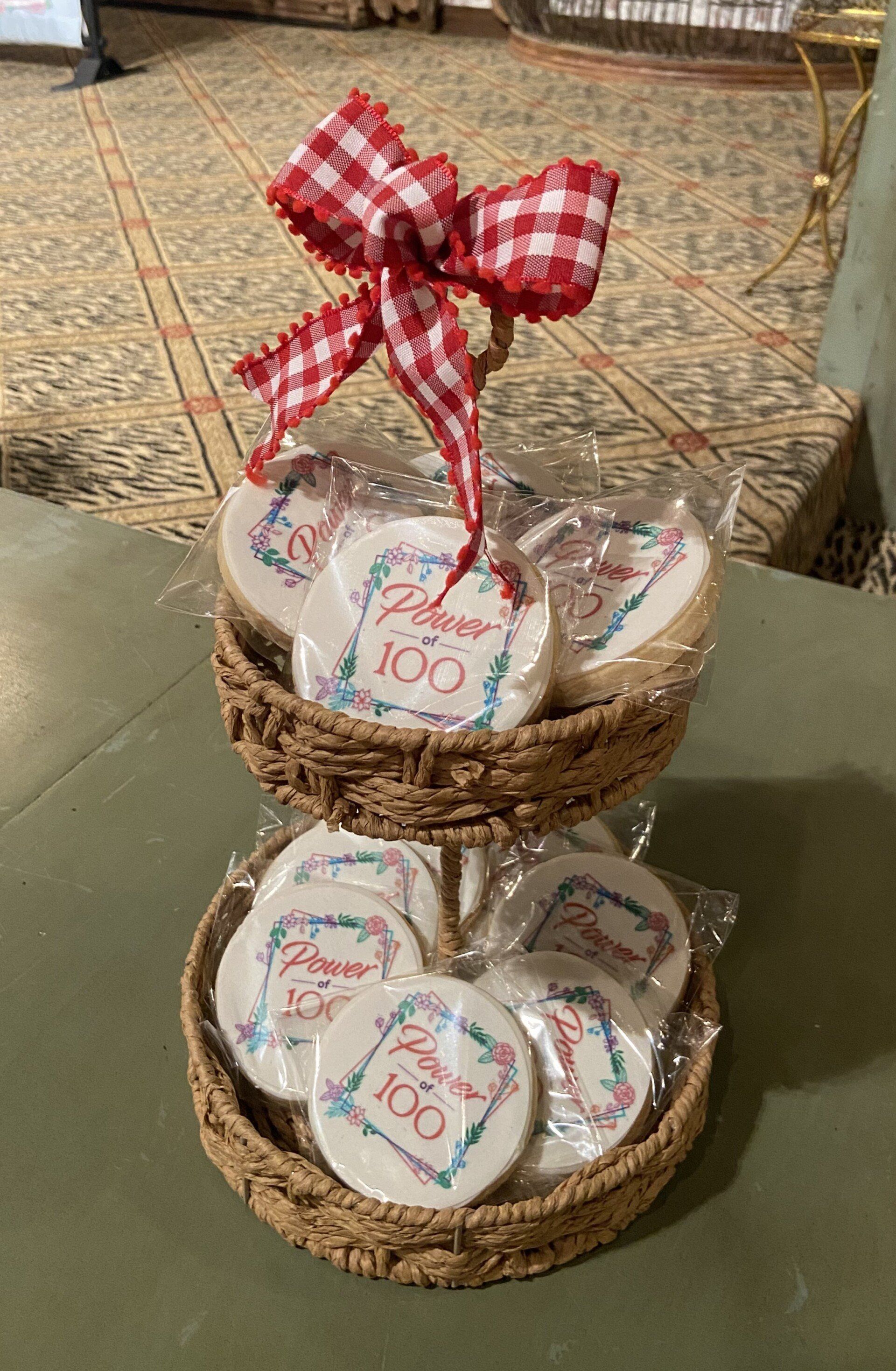 A wicker tray filled with cookies with a red and white checkered bow.