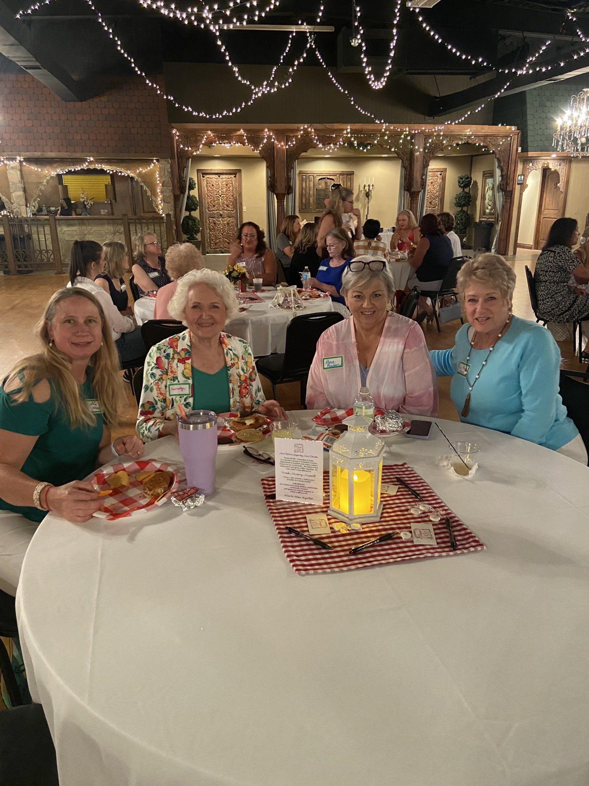 A group of women are sitting at a table in a room.