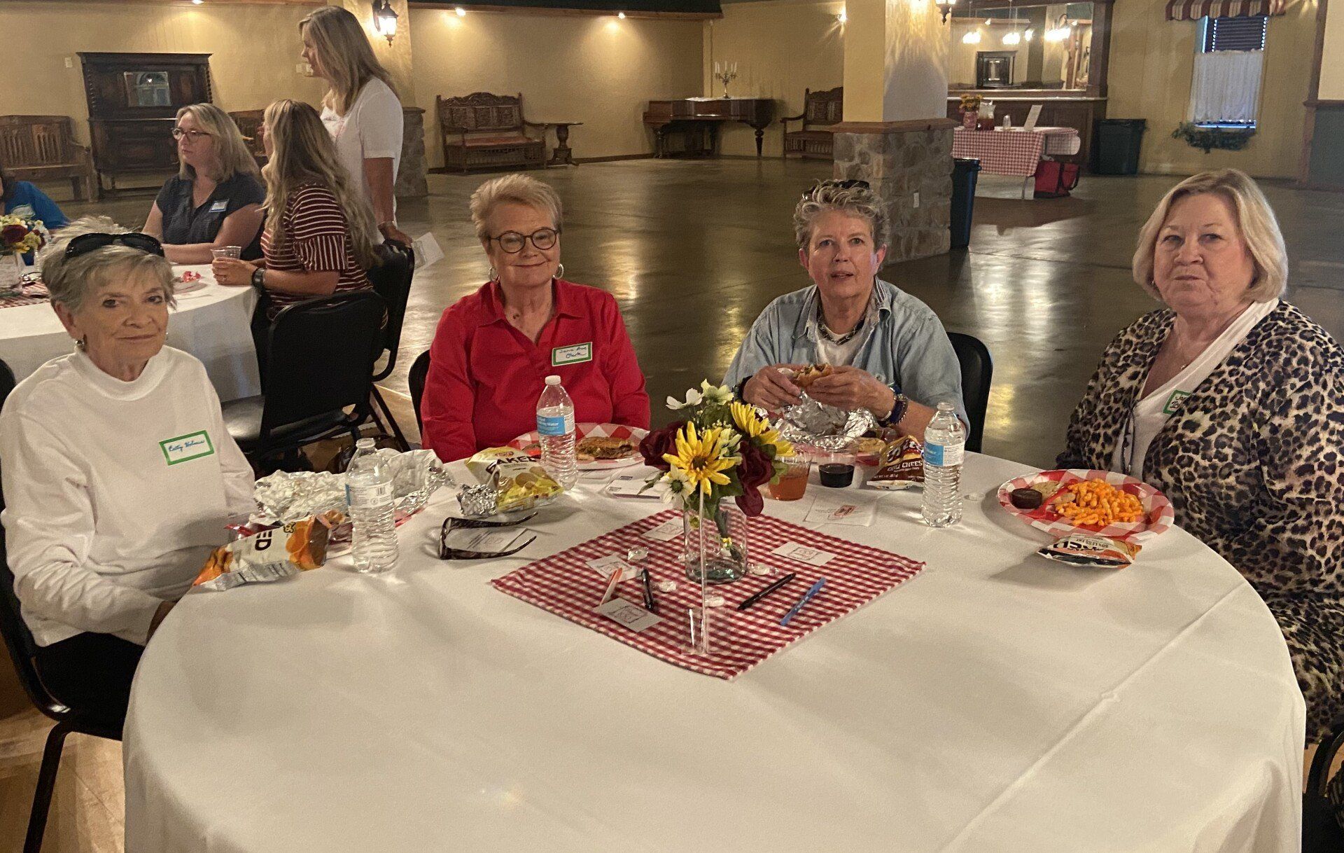 A group of women are sitting at a table with plates of food.