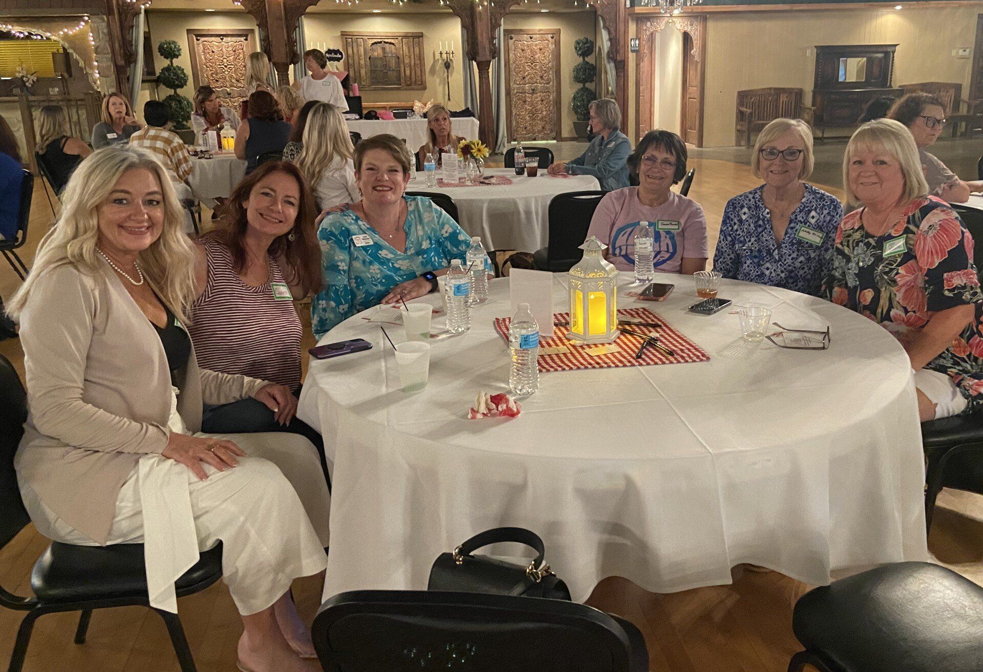 A group of women are sitting at a table in a room.