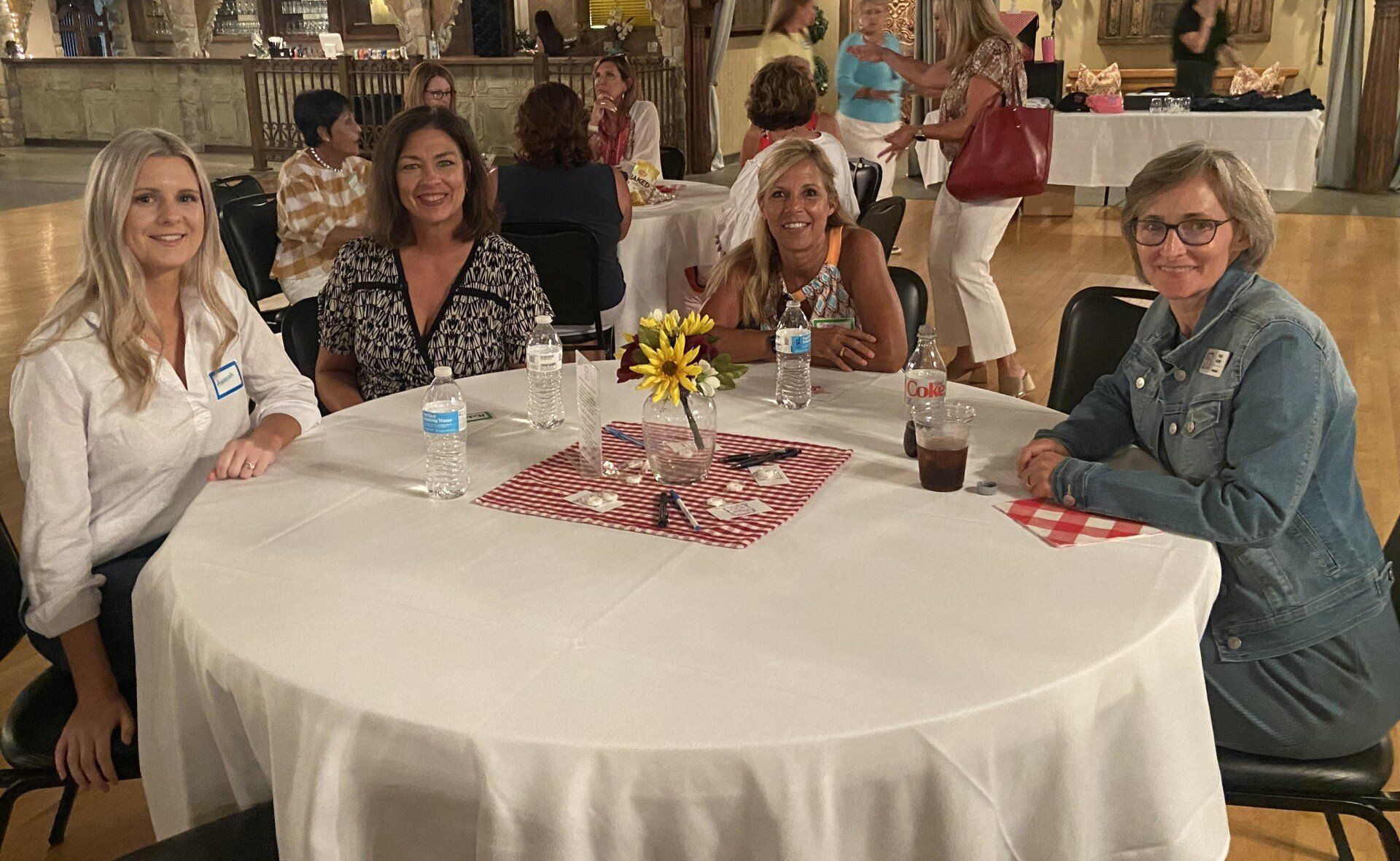 A group of women are sitting at a table in a room.