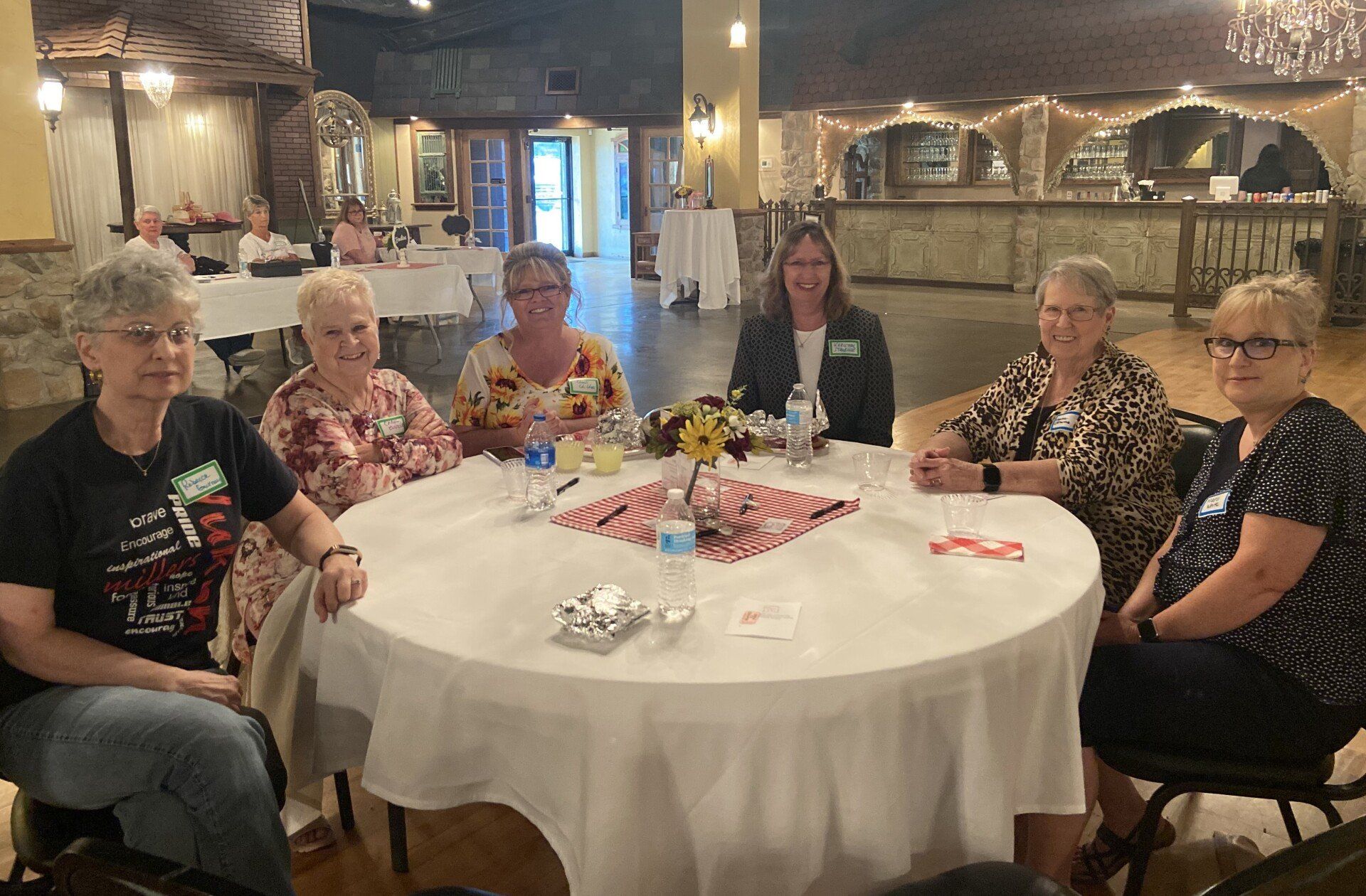 A group of women are sitting around a table in a room.