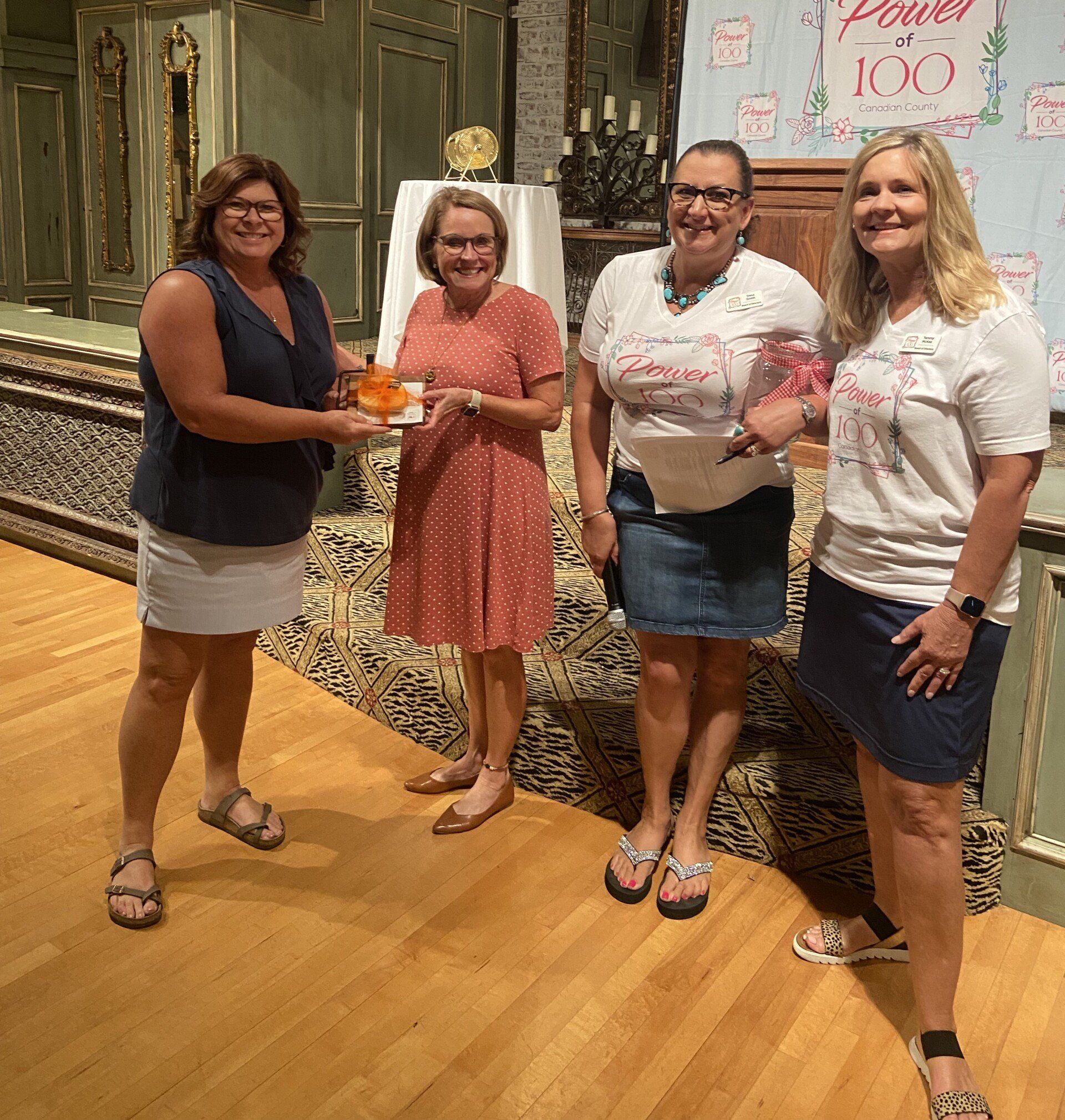 A group of women are standing next to each other on a wooden floor.