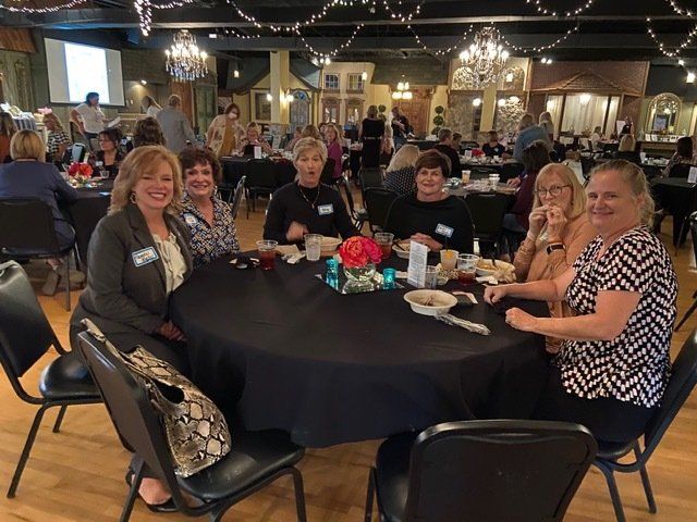 A group of women are sitting around a table in a restaurant