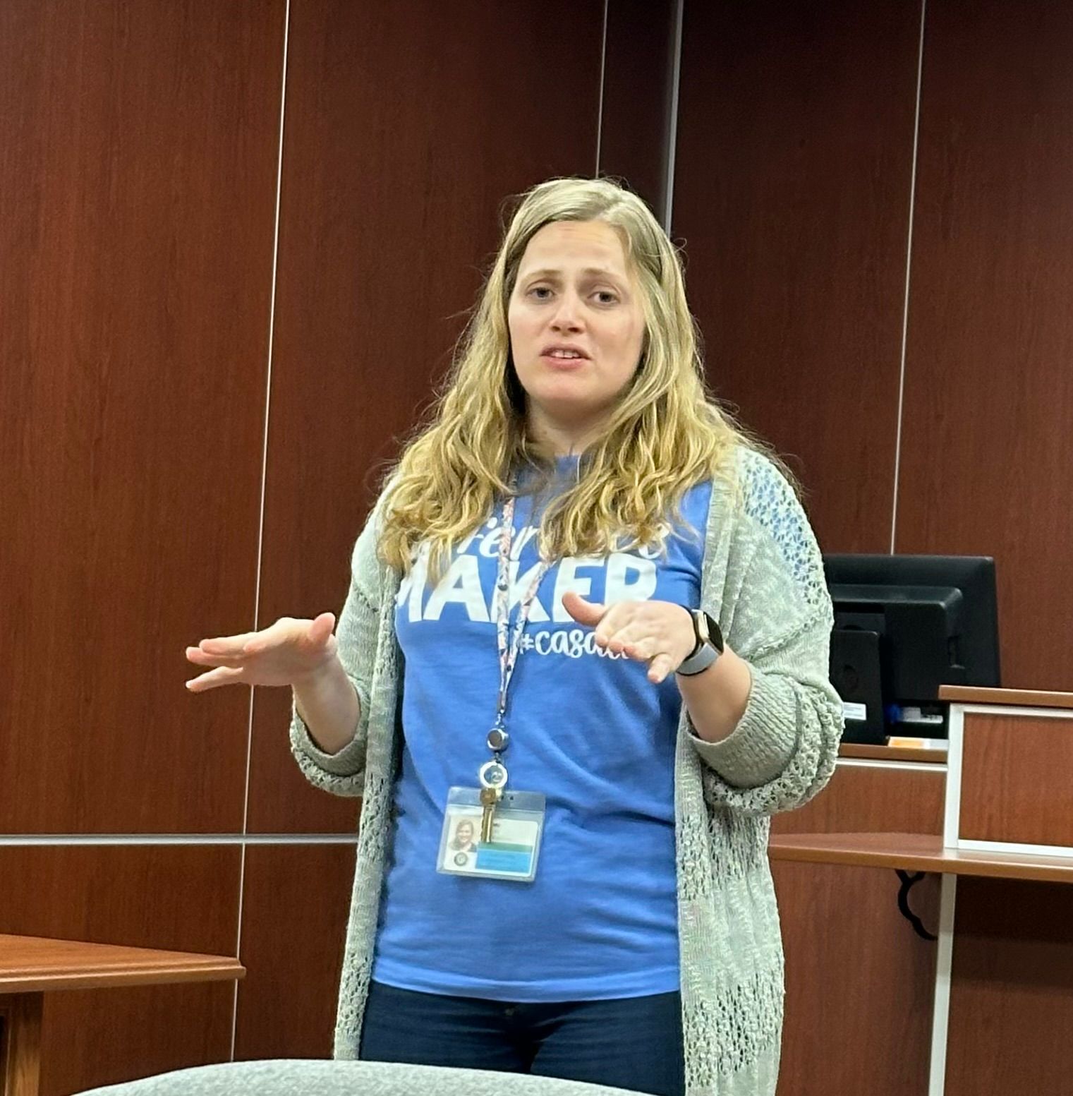 A woman wearing a blue shirt that says be the maker