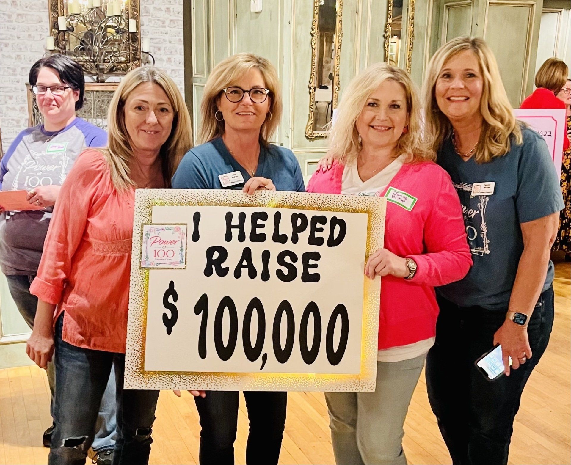 A group of women holding a sign that says i helped raise $ 100,000