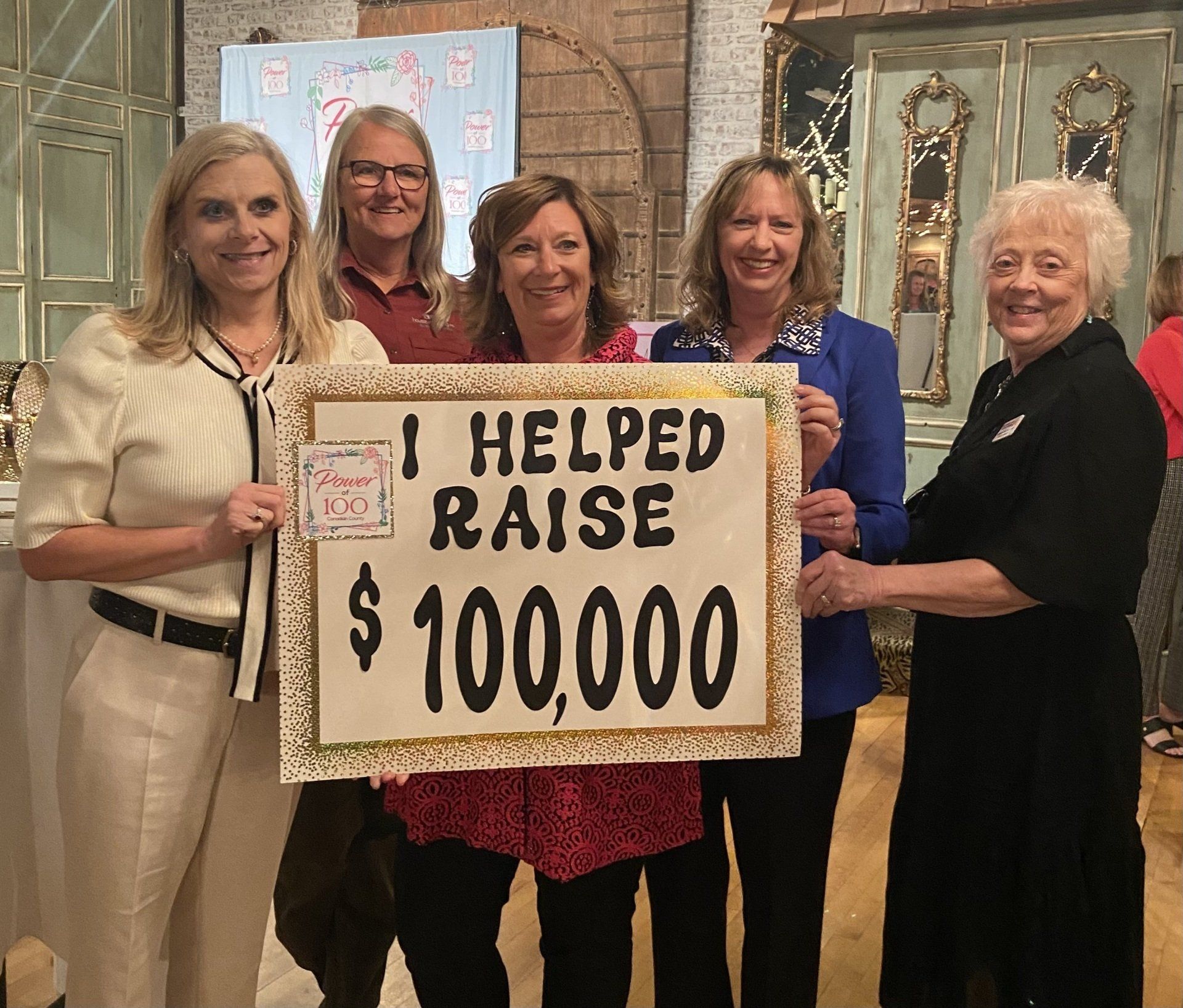 A group of women holding a sign that says i helped raise $ 100,000