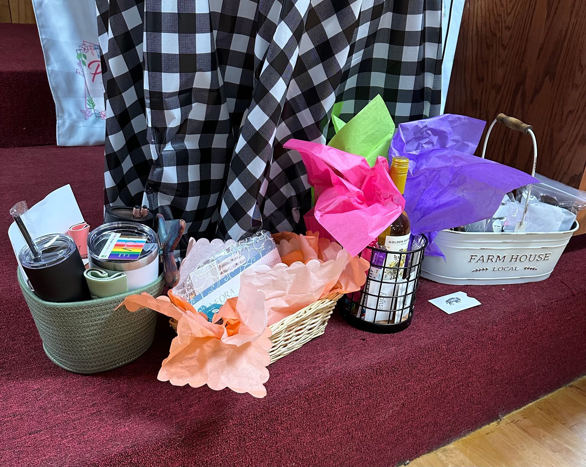 A basket filled with tissue paper and a bottle of wine
