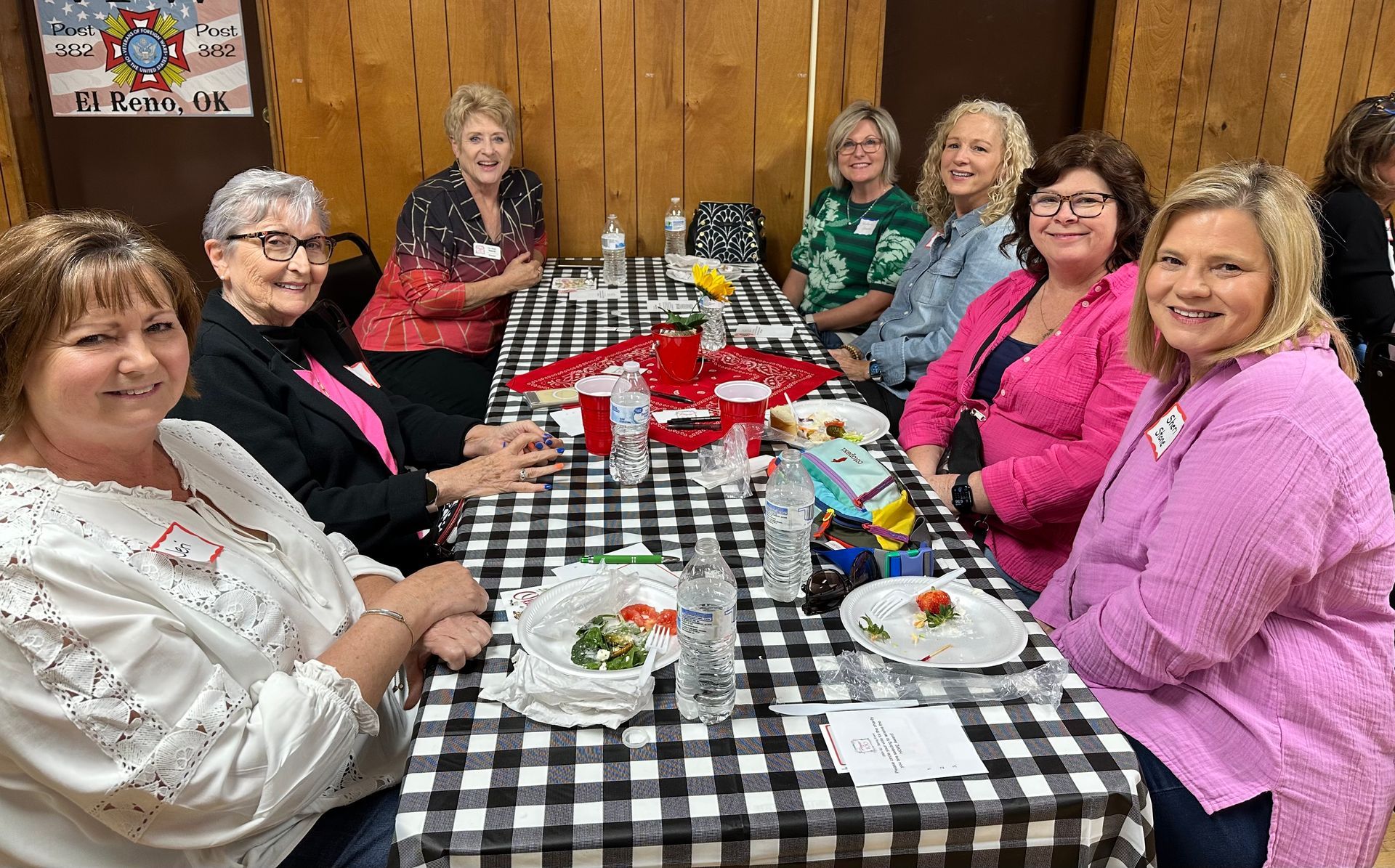 A group of women are sitting at a table with plates of food.