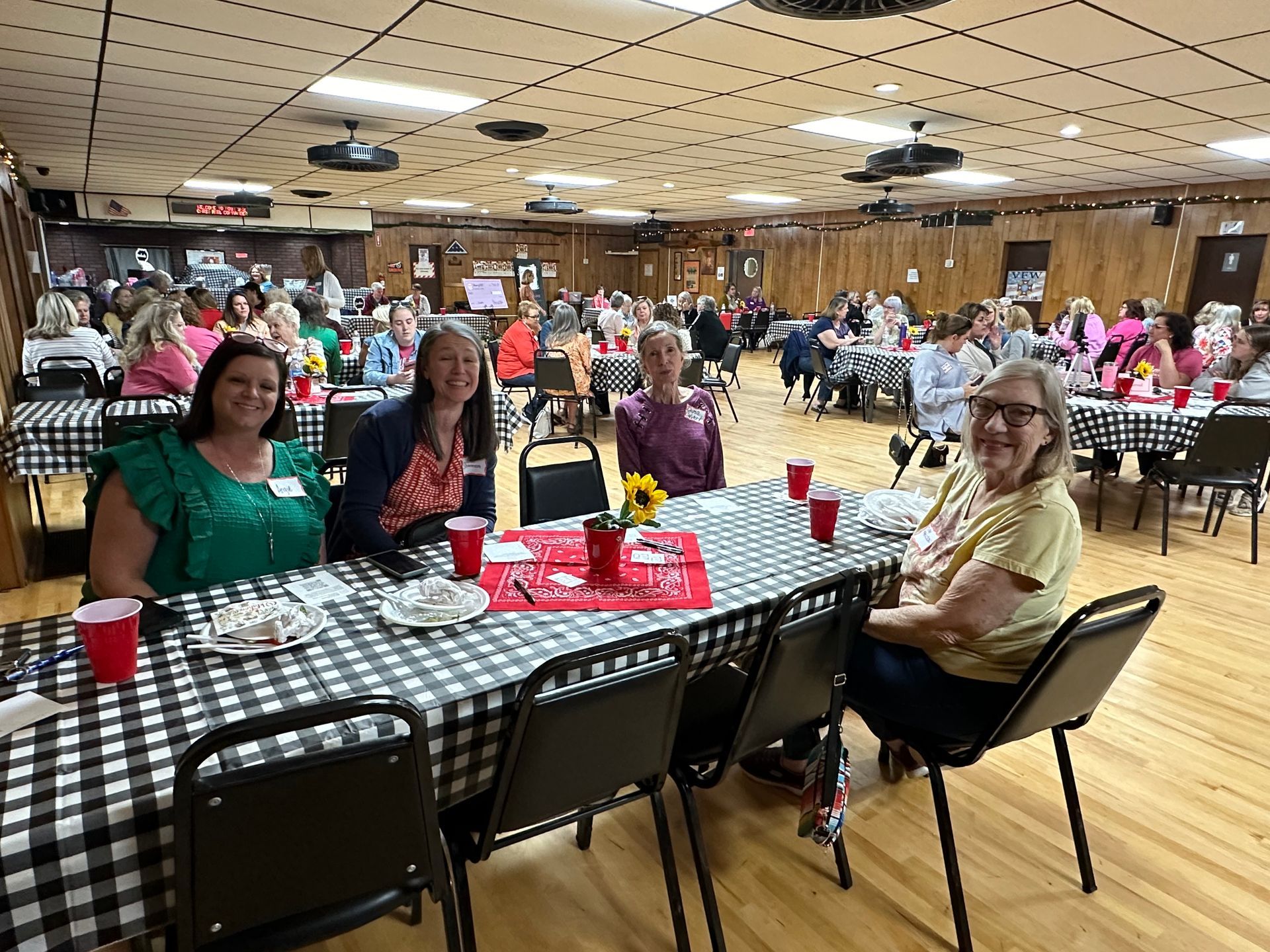 A group of people are sitting at tables in a large room.