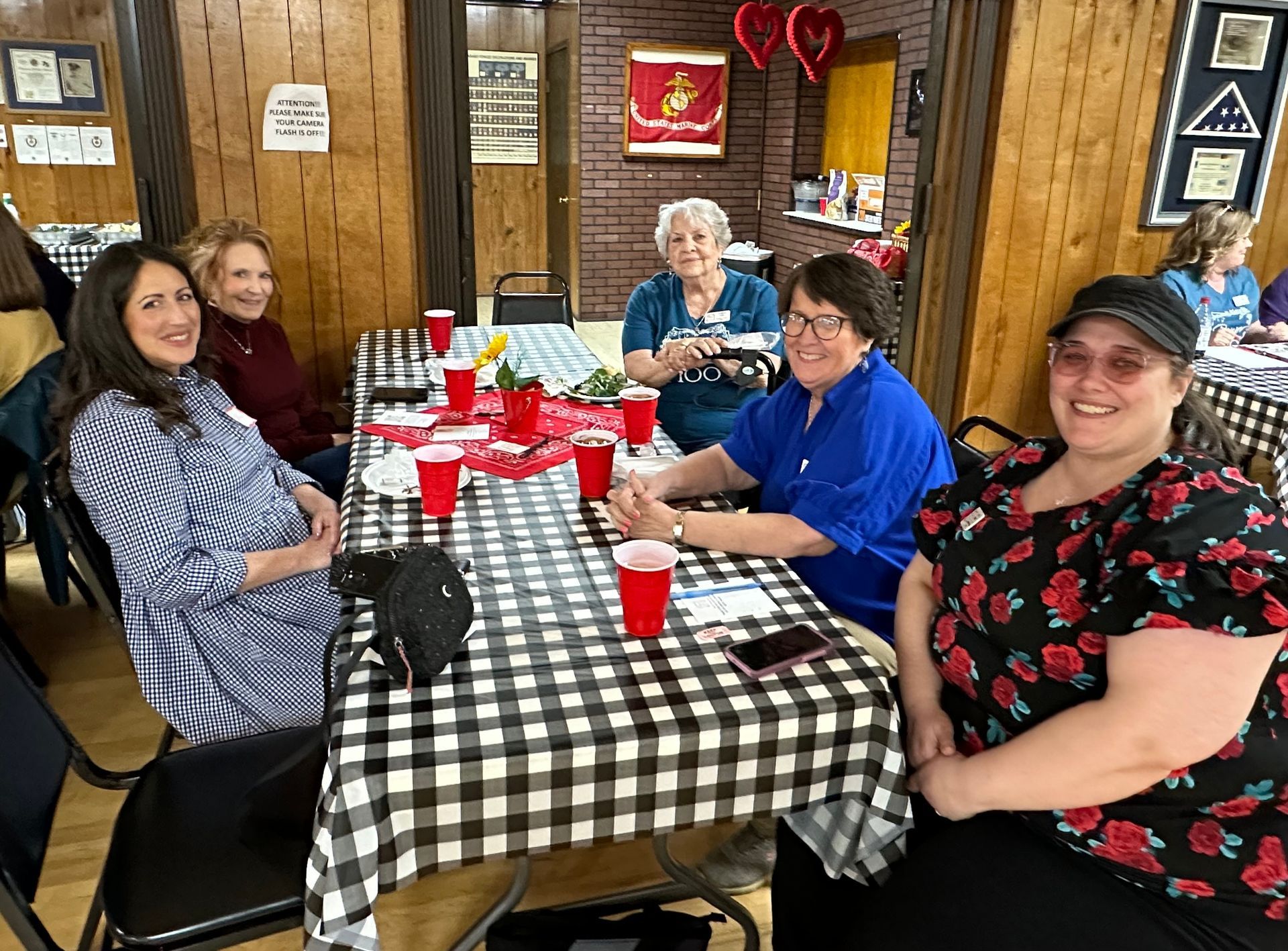 A group of women are sitting at a table with red cups.