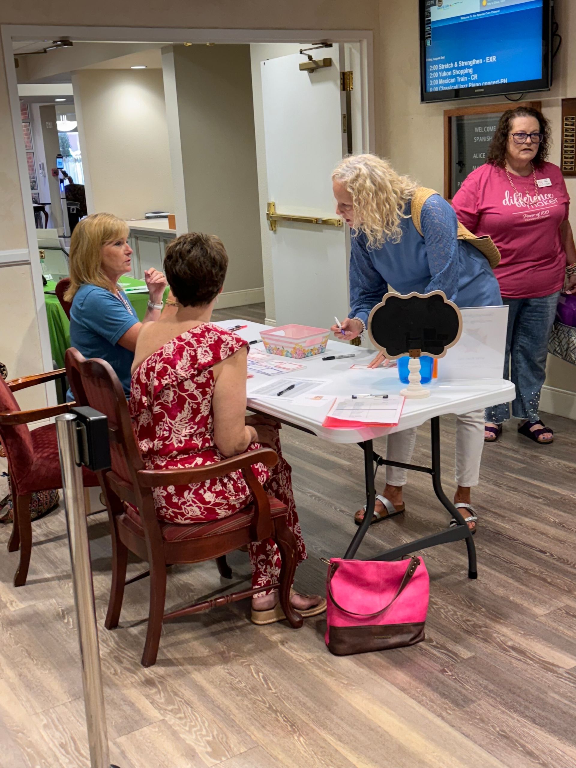 A group of women are sitting at a table in a room.