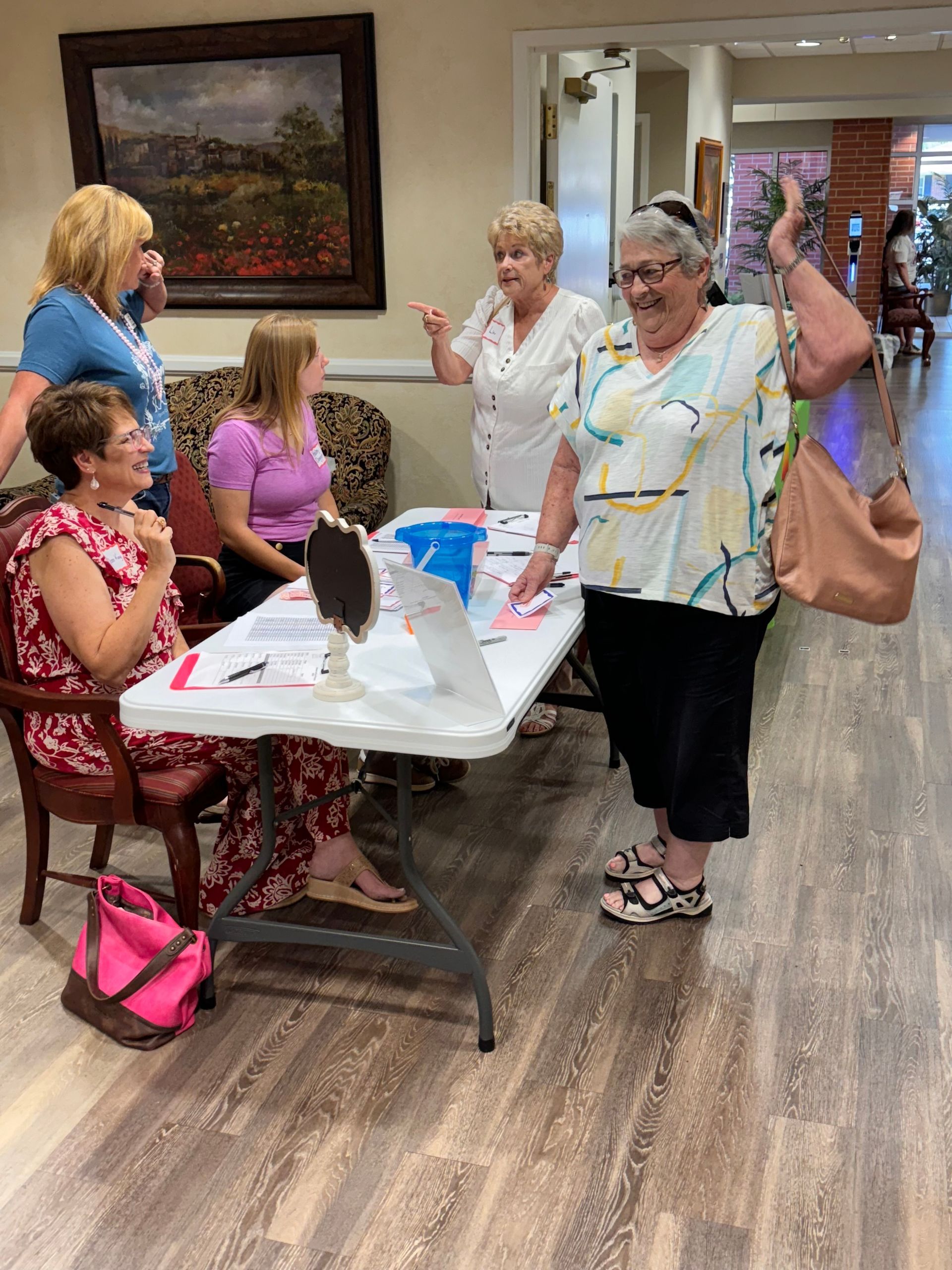 A group of women are standing around a table in a room.