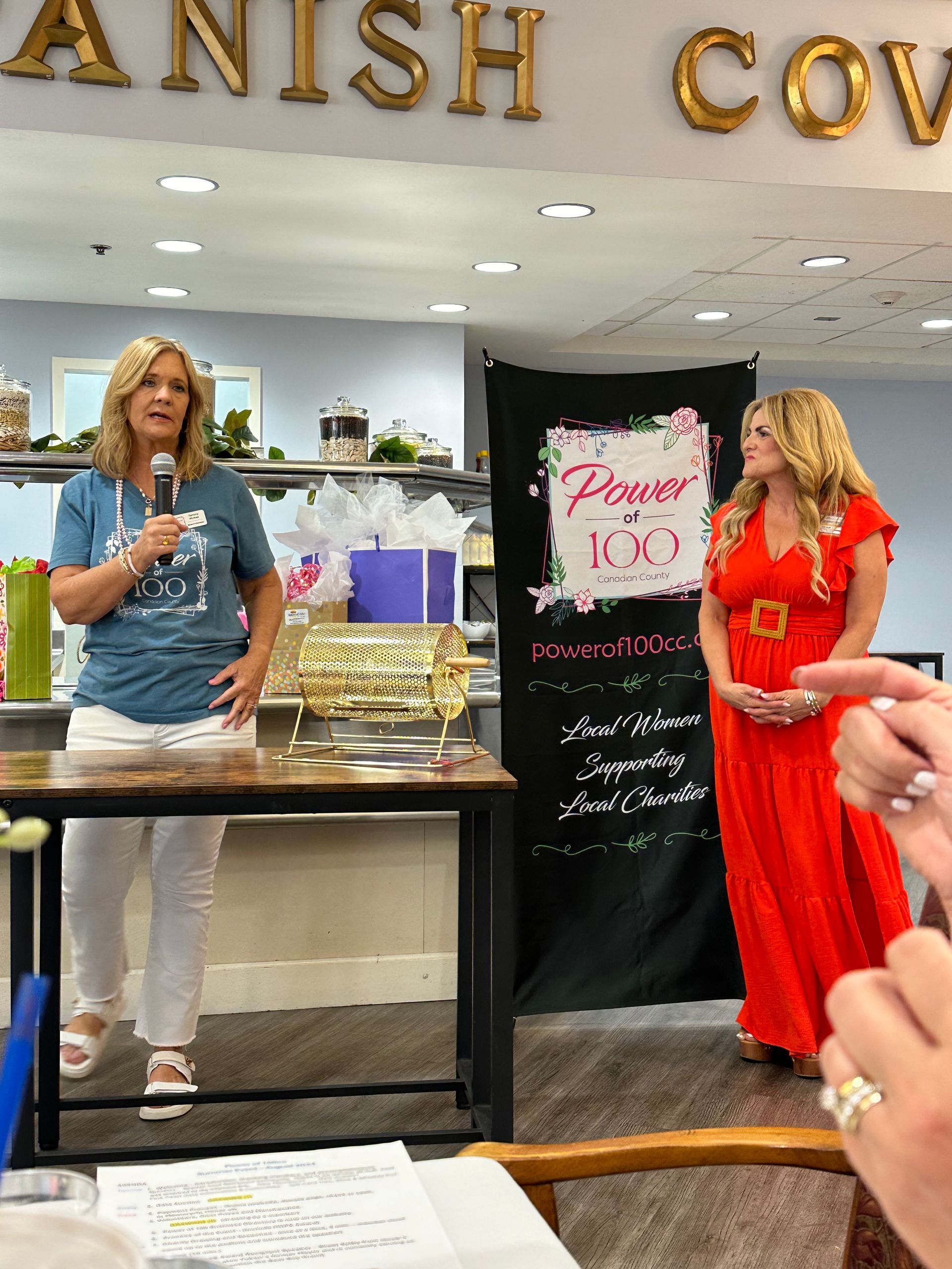 Two women standing in front of a sign that says prayer kid
