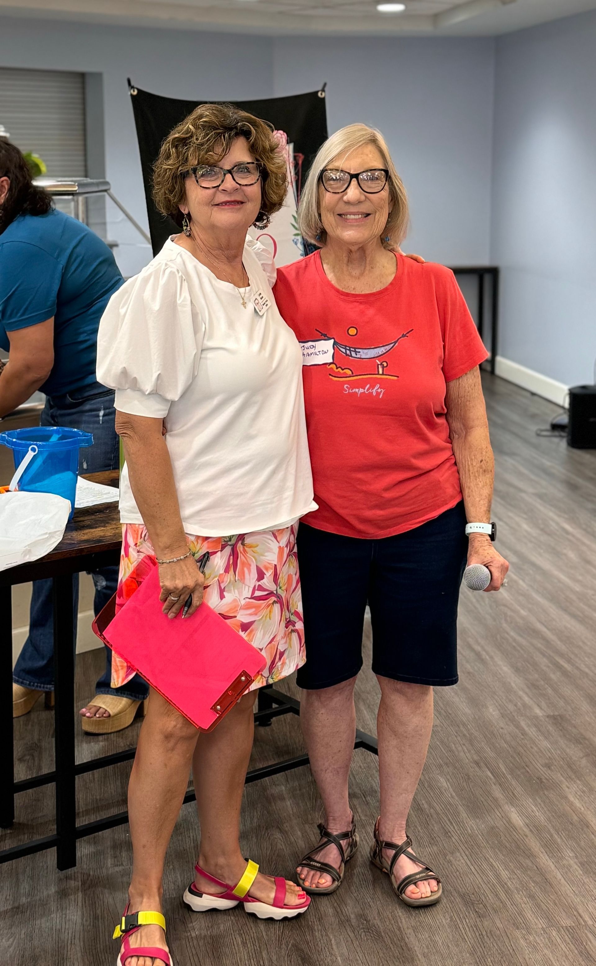 Two women are standing next to each other in a room.