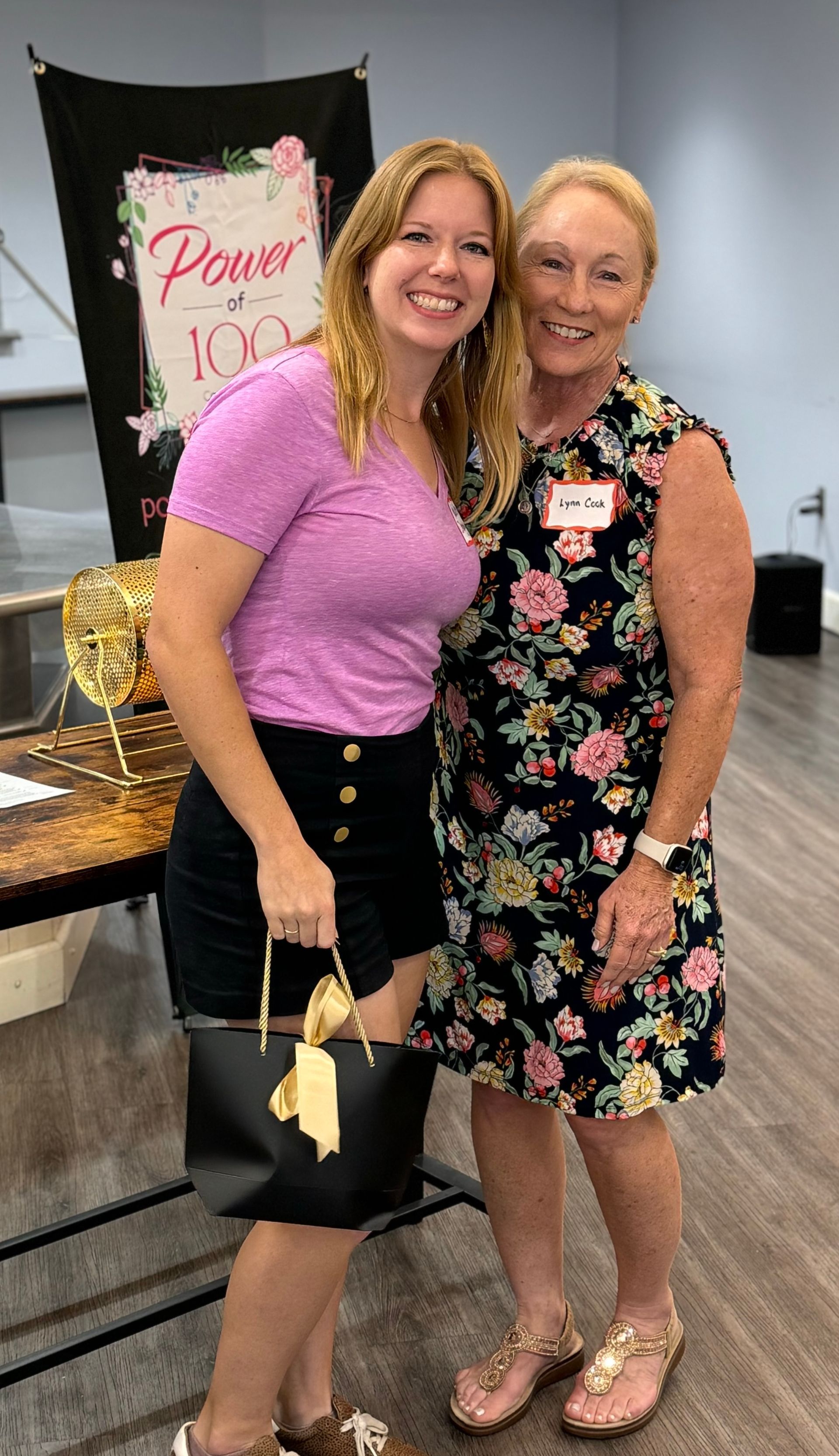 Two women are posing for a picture together in a room.