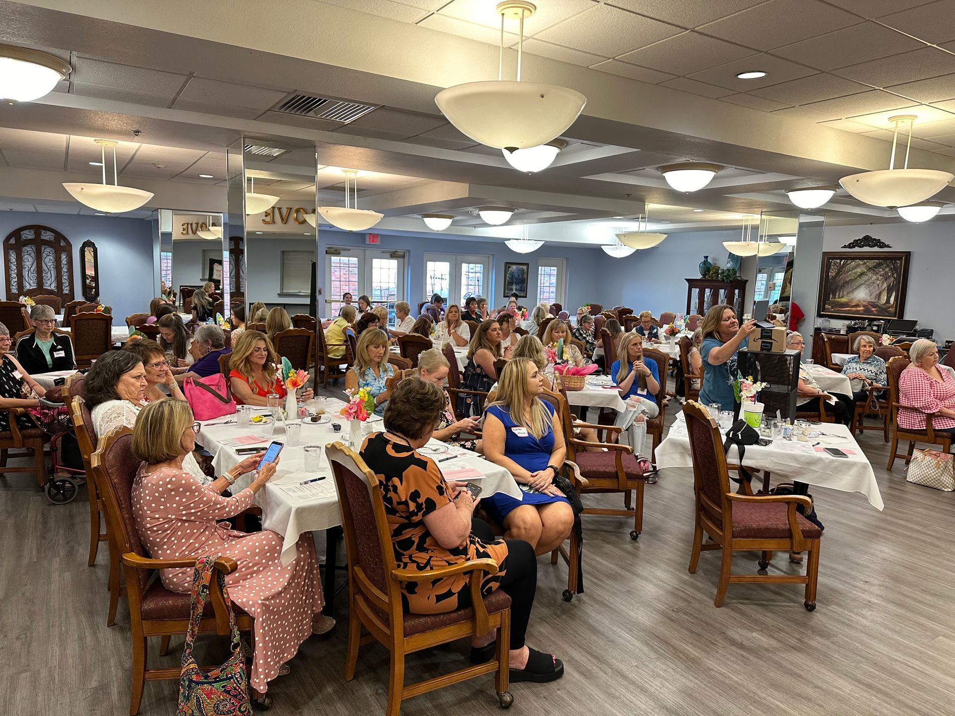 A large group of people are sitting at tables in a large room.