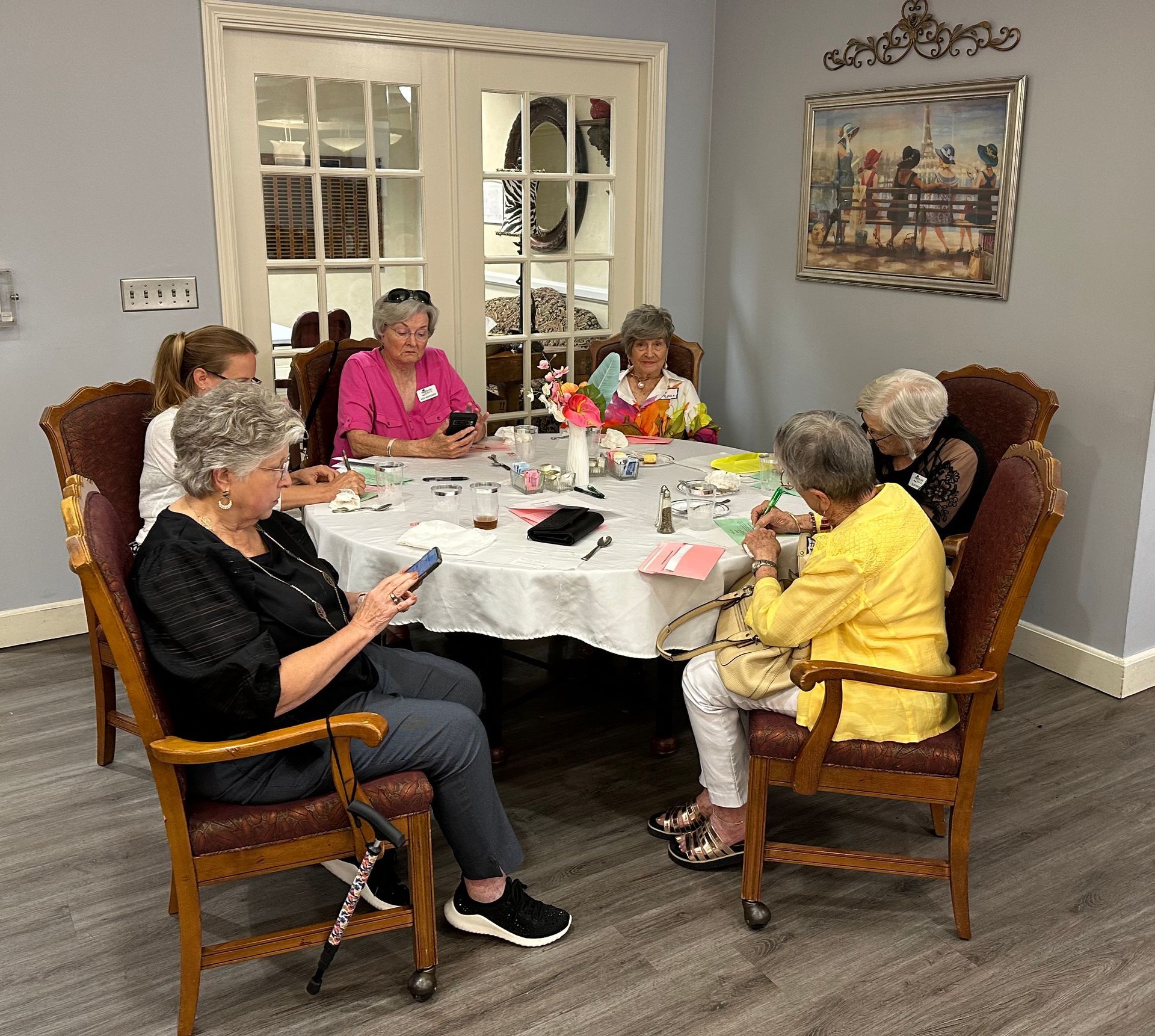 A group of women are sitting around a table in a room.
