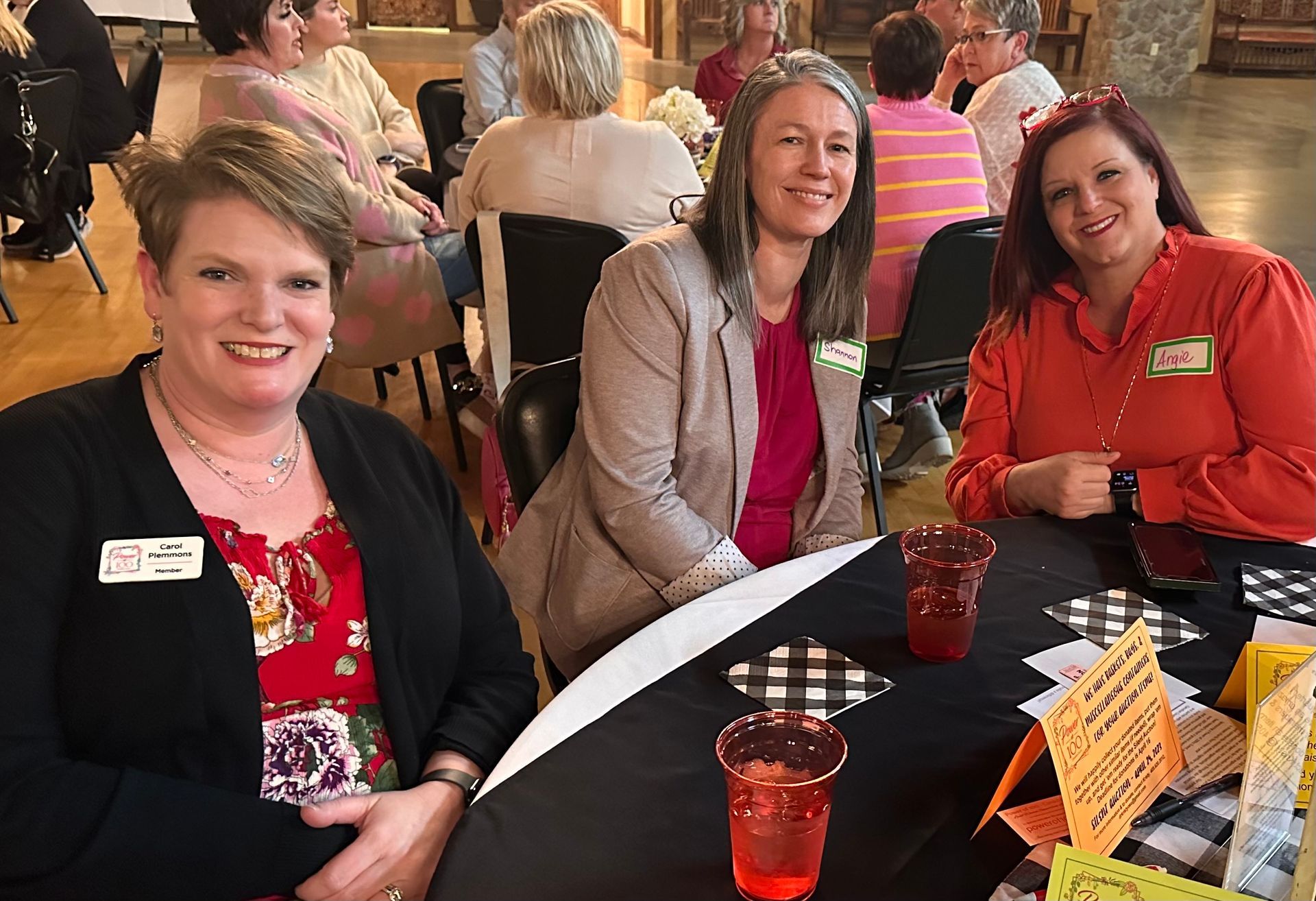 A group of women are sitting at a table with drinks.