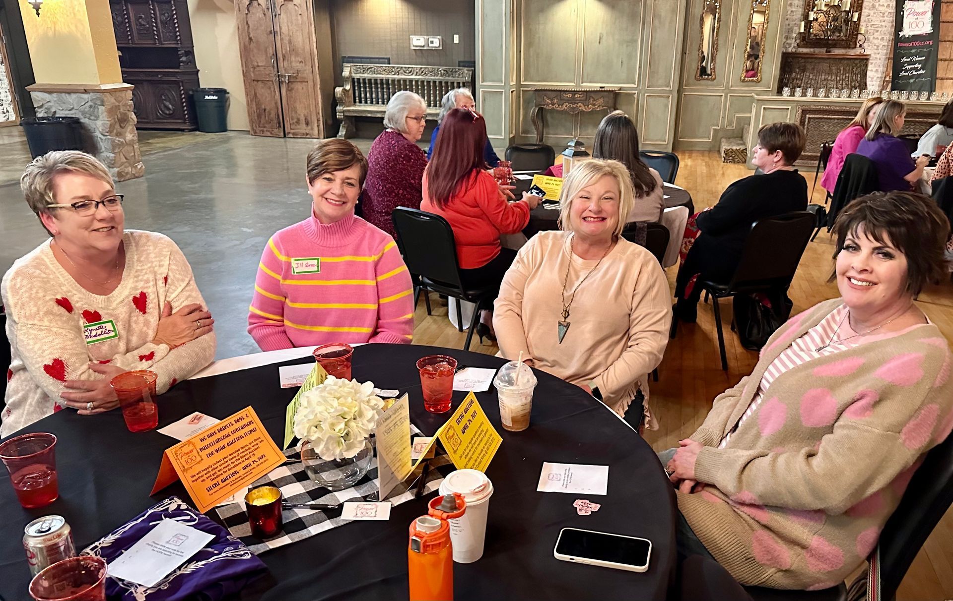 A group of women are sitting around a table with drinks.