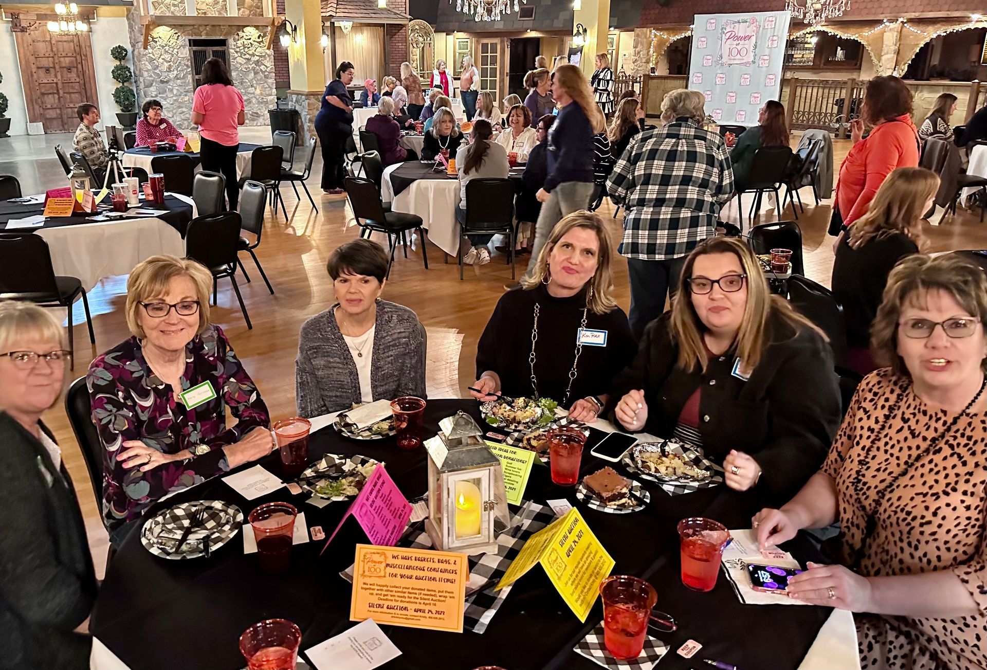 A group of women are sitting at a table with plates of food.