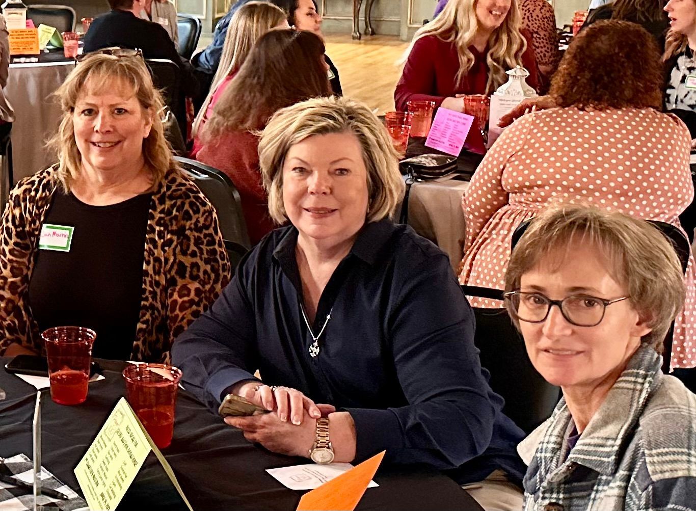 A group of women are sitting at a table at a party.