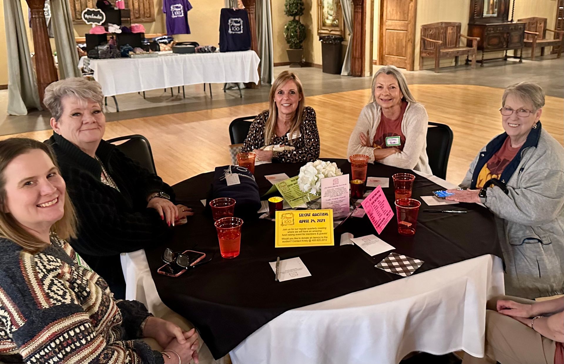 A group of women are sitting around a table with drinks.