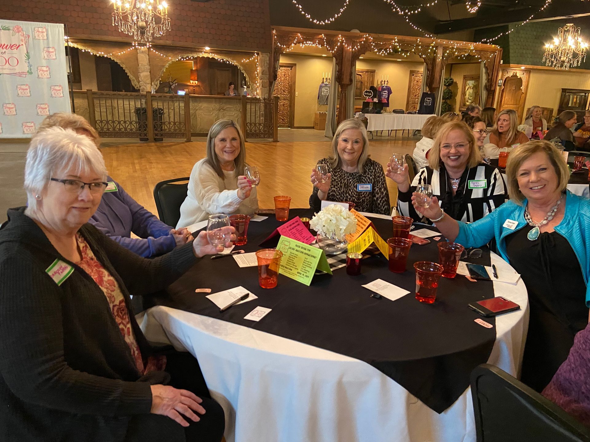 A group of women are sitting around a table with glasses of water