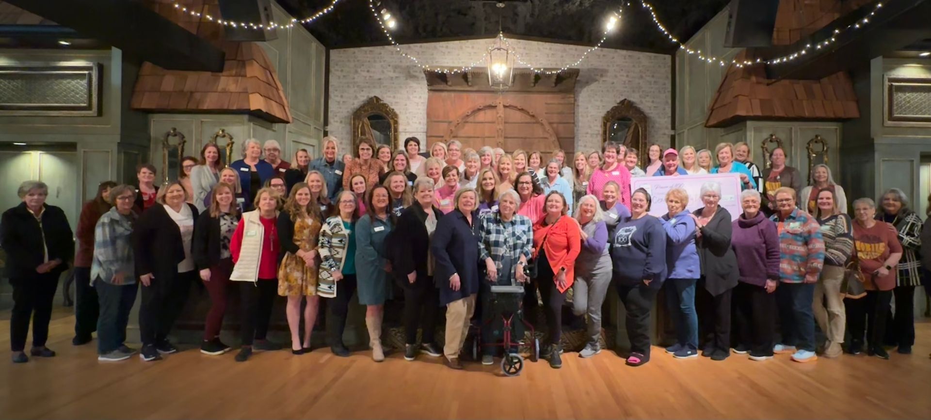 A large group of people are posing for a picture in a room.