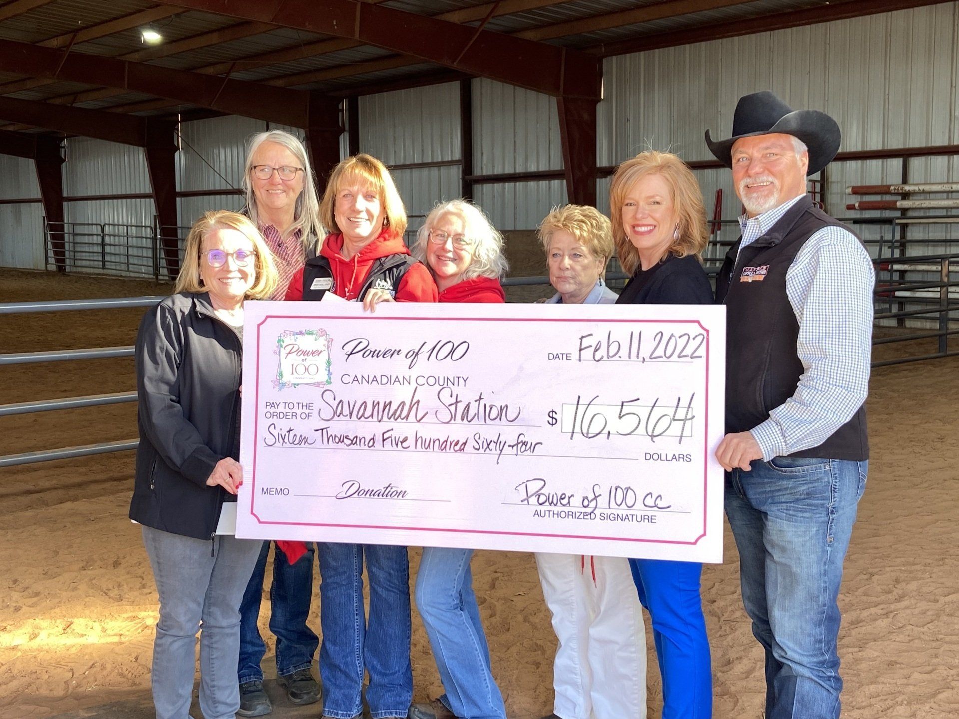 A group of people standing next to each other holding a large check.