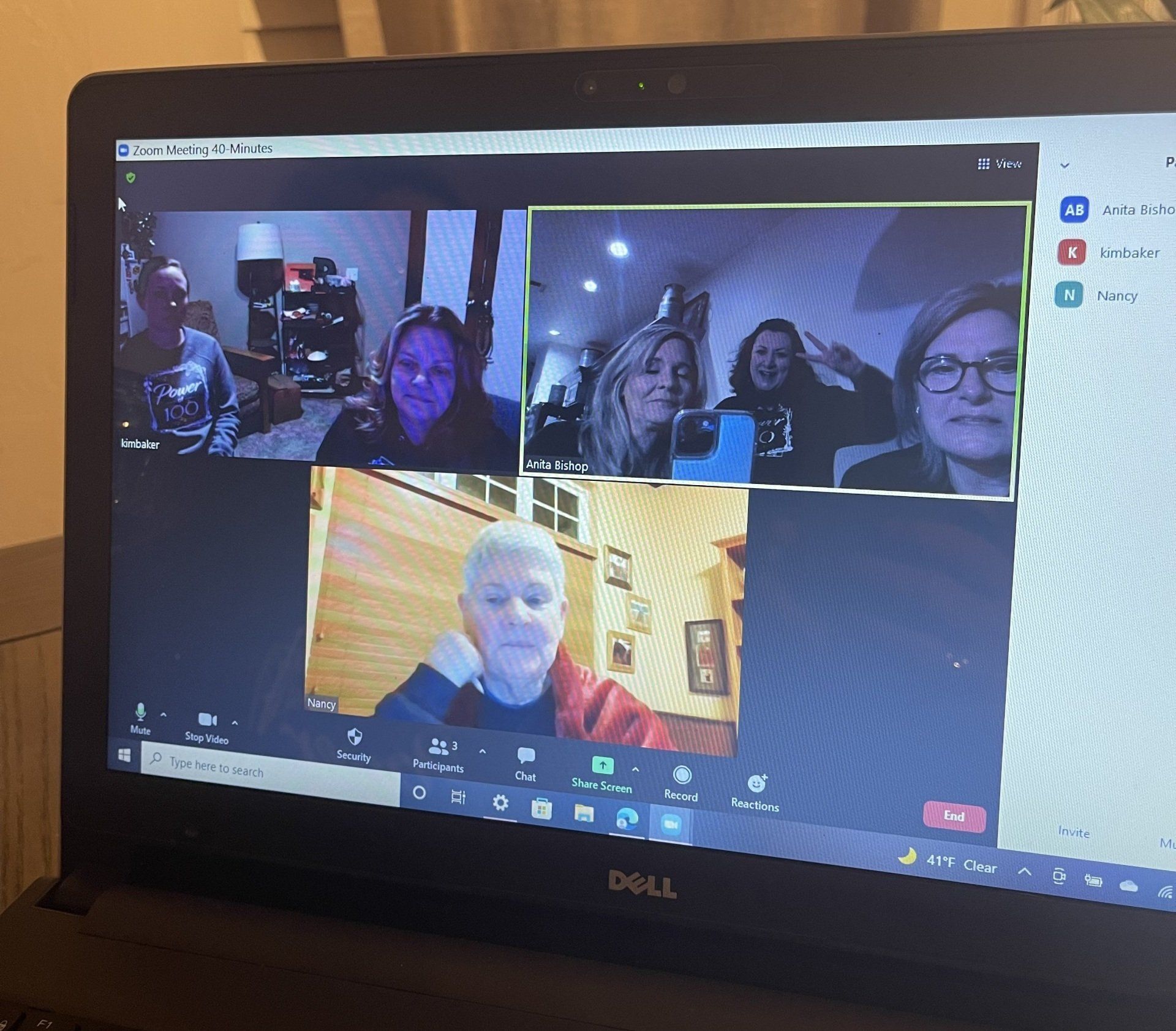 A group of people are having a video call on a dell laptop.