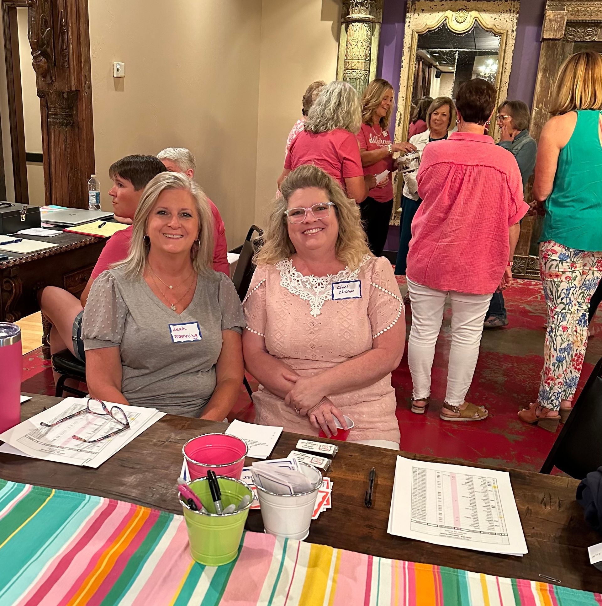 A group of women are sitting at a table in a room.