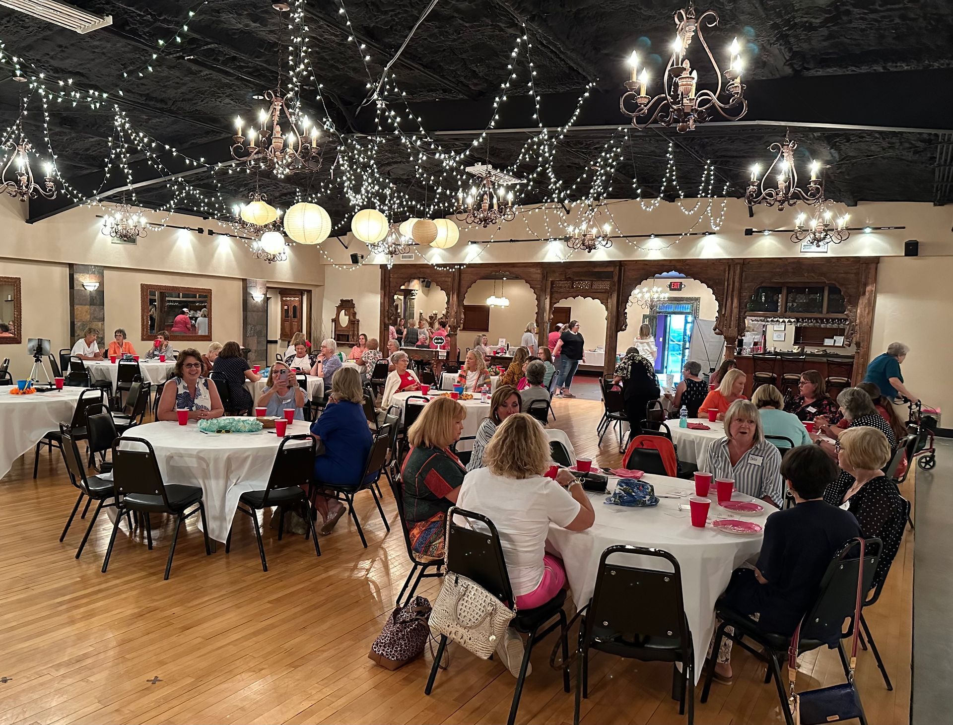 A large group of people are sitting at tables in a large room.