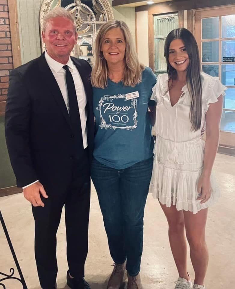 A man in a suit and tie is posing for a picture with two women.