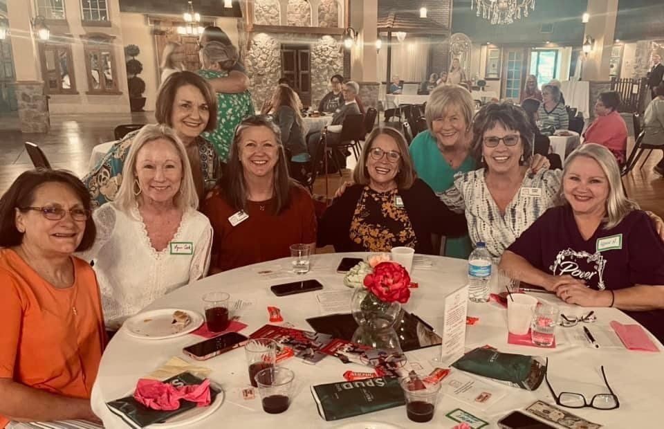 A group of women are sitting around a table in a restaurant.