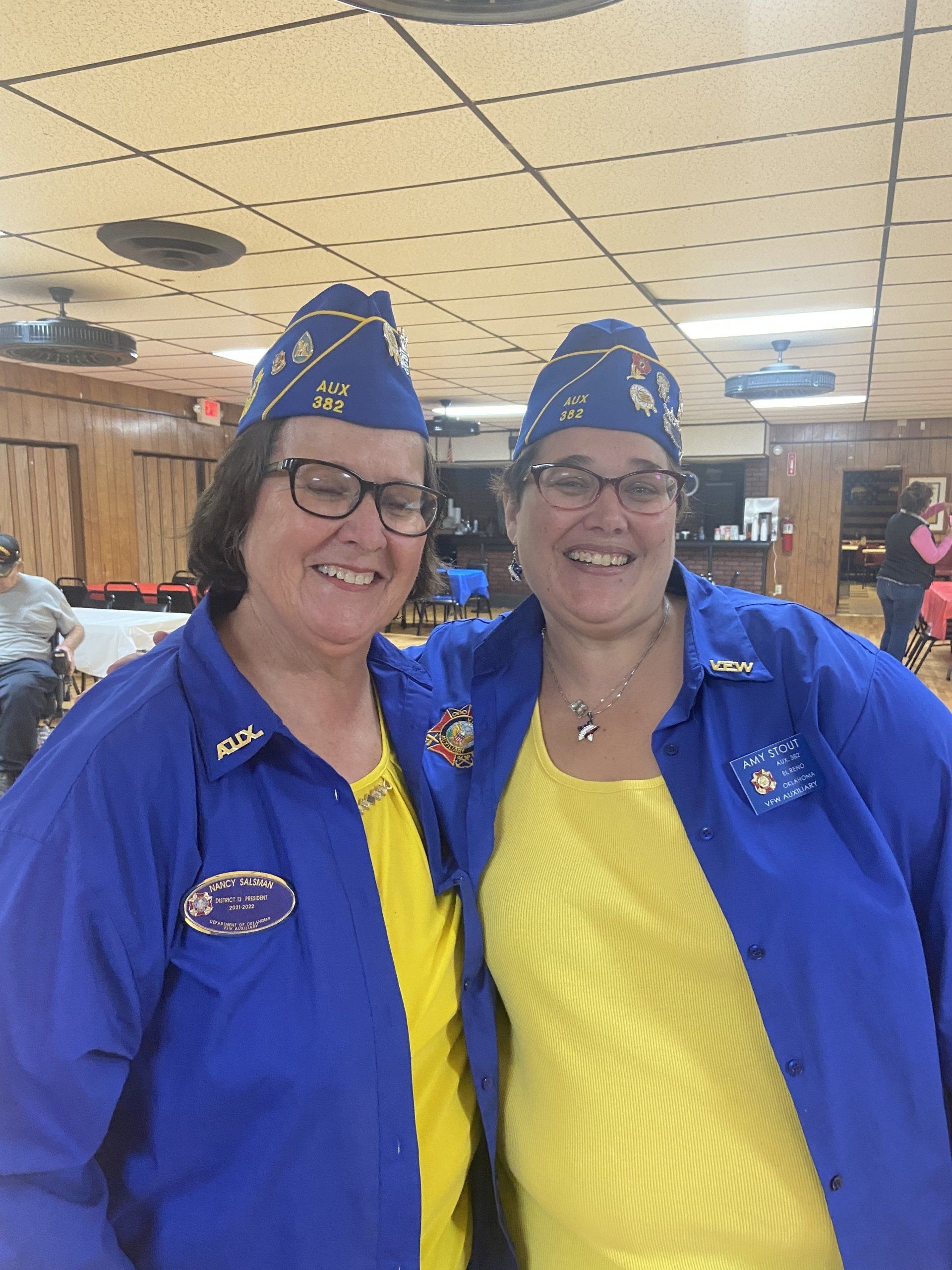 Two women wearing blue jackets and hats are posing for a picture.