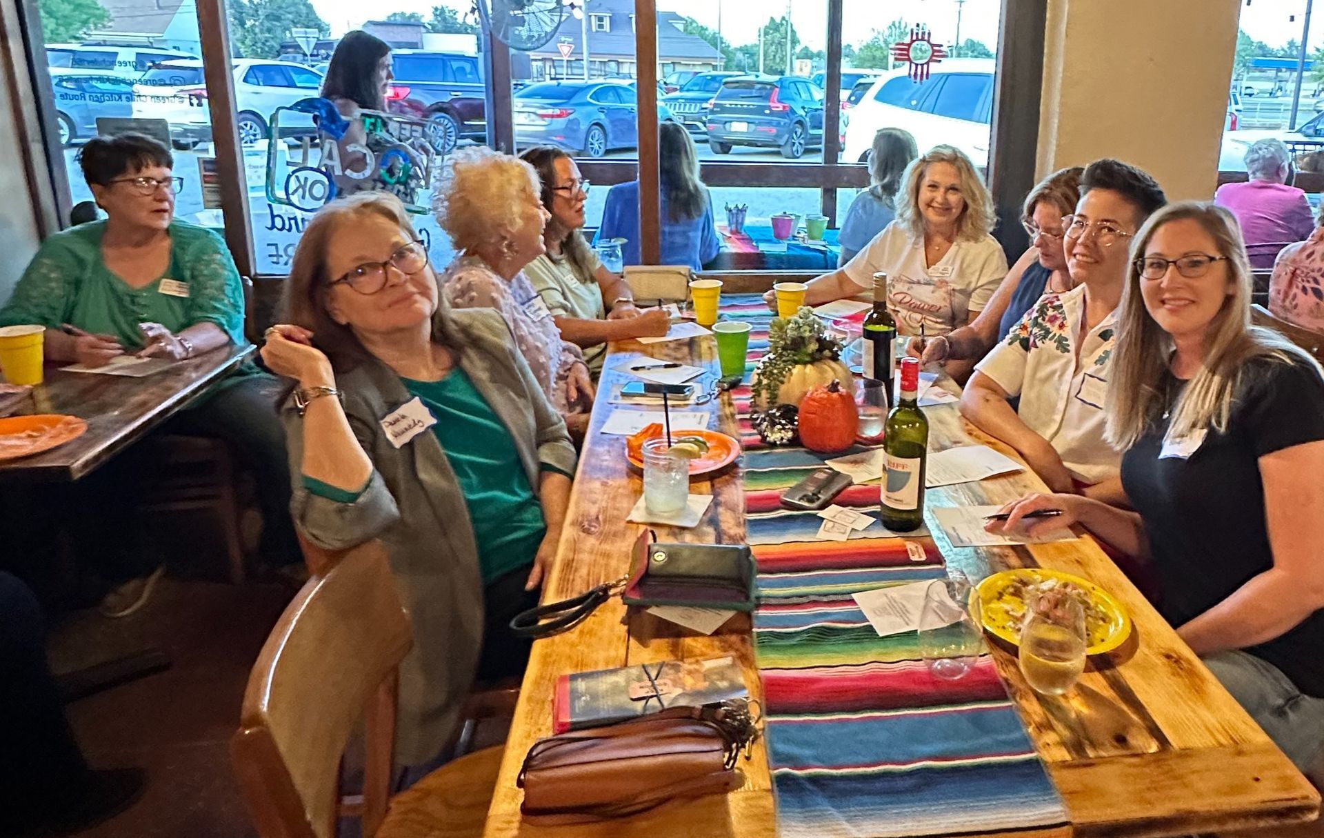 A group of people are sitting at a long table in a restaurant.